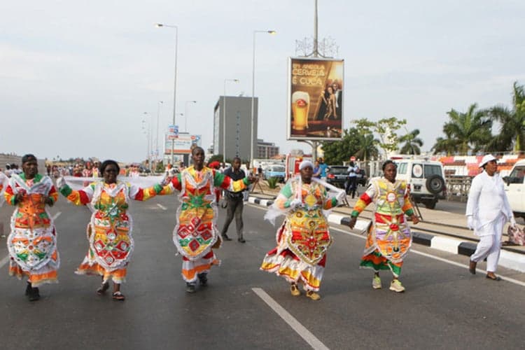 Parade of dancers in brilliant feathered costumes at Carnival de Luanda