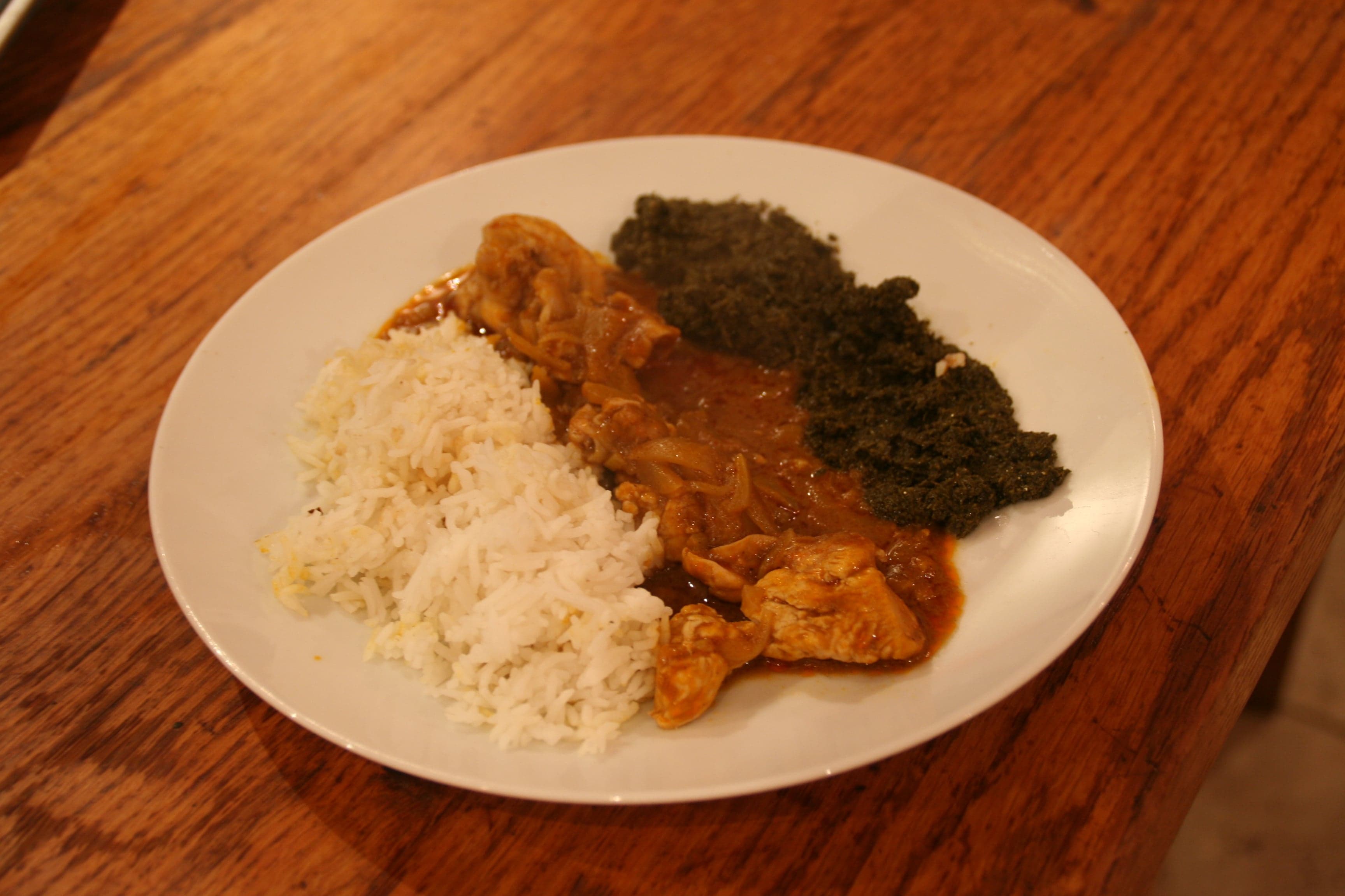 Bowl of rich orange muamba de galinha chicken stew with okra and palm oil
