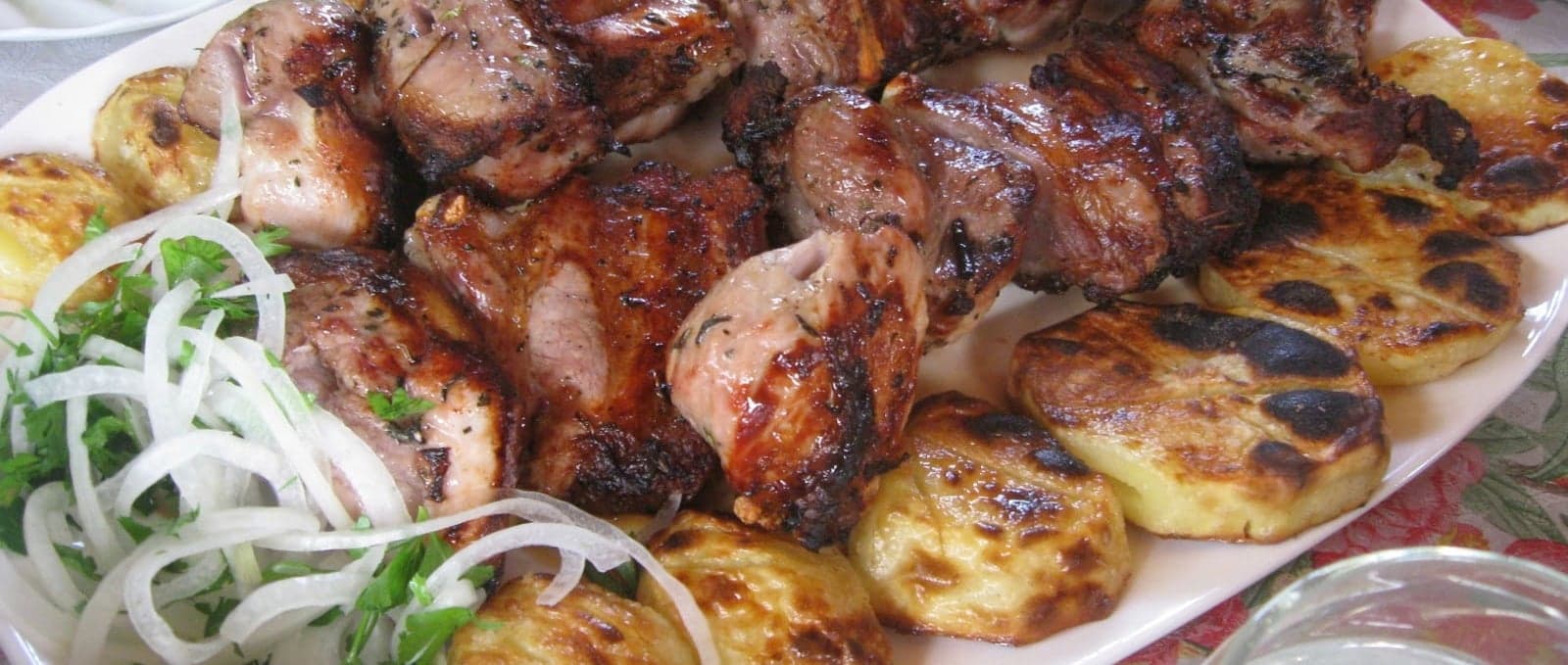 Skewers of khorovats grilling over an open wood fire