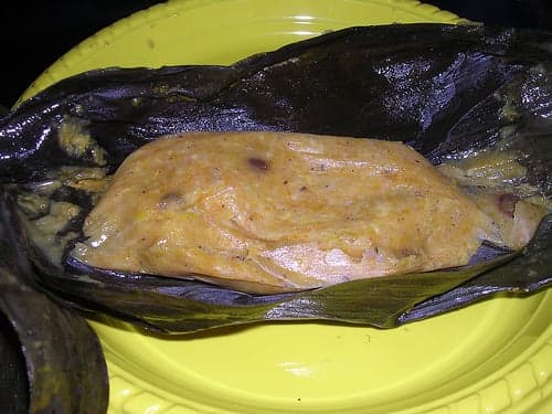 A conkie unwrapped from its banana leaf, showing the golden sweet cornmeal inside