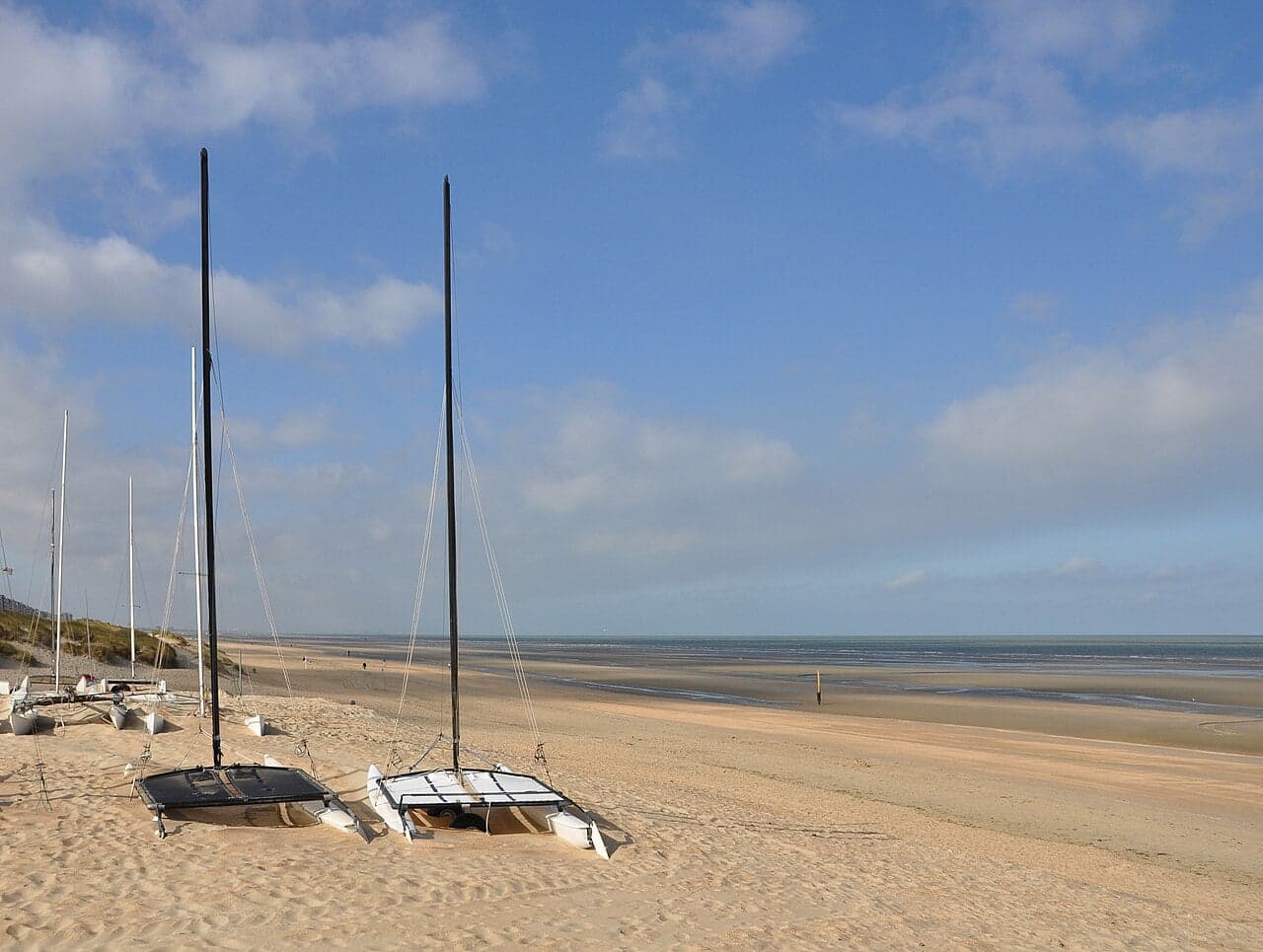 Wide sandy beach with colourful beach huts along the Belgian coast