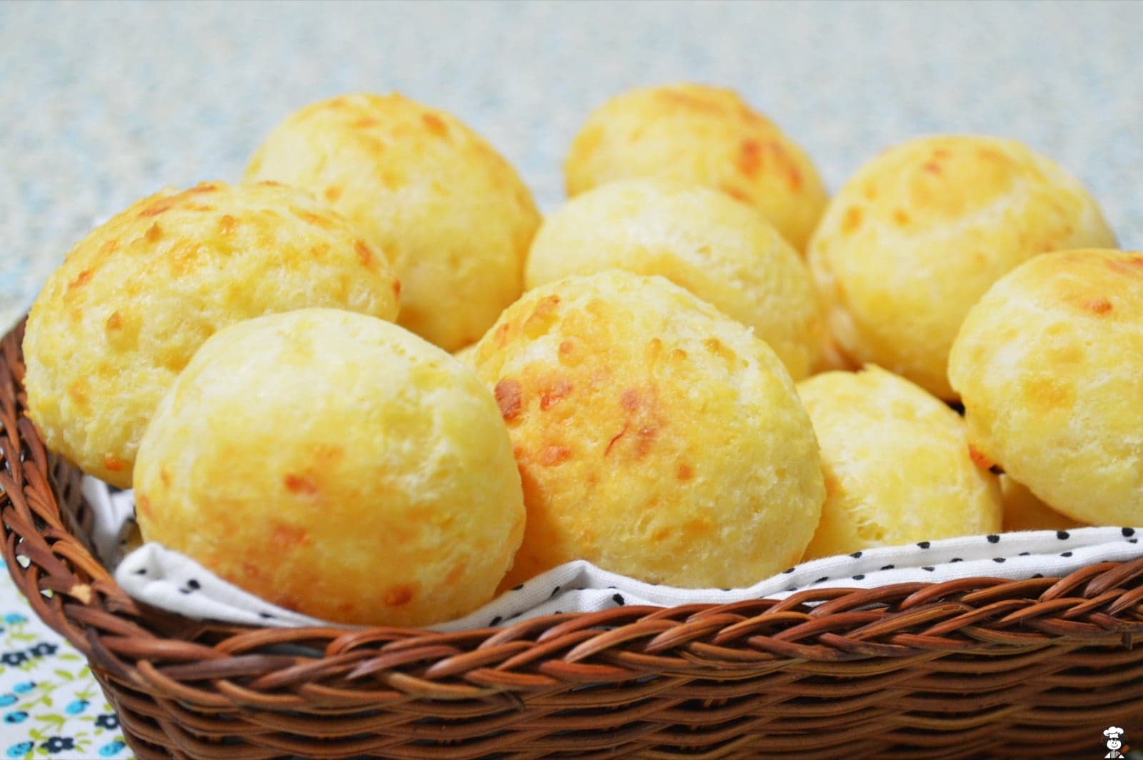 A basket of warm pão de queijo - small golden cheese breads