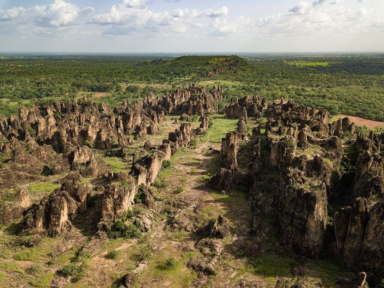 Tall jagged limestone spires of Sindou rising above the trees