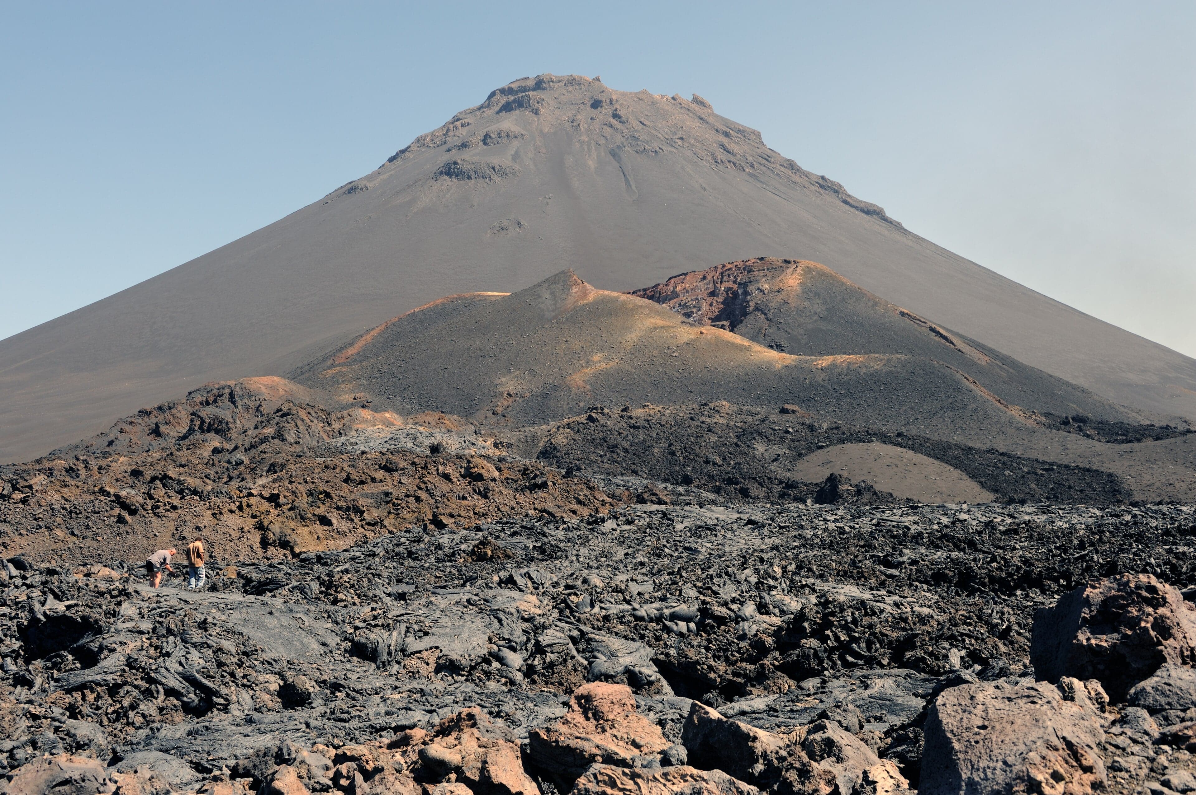 The perfect cone of Pico do Fogo rising above dark volcanic rock and a small village