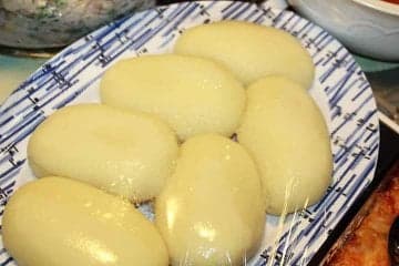 Smooth white balls of fufu served alongside a rich stew