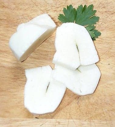 Golden-brown slices of grilled halloumi cheese on a white plate with lemon