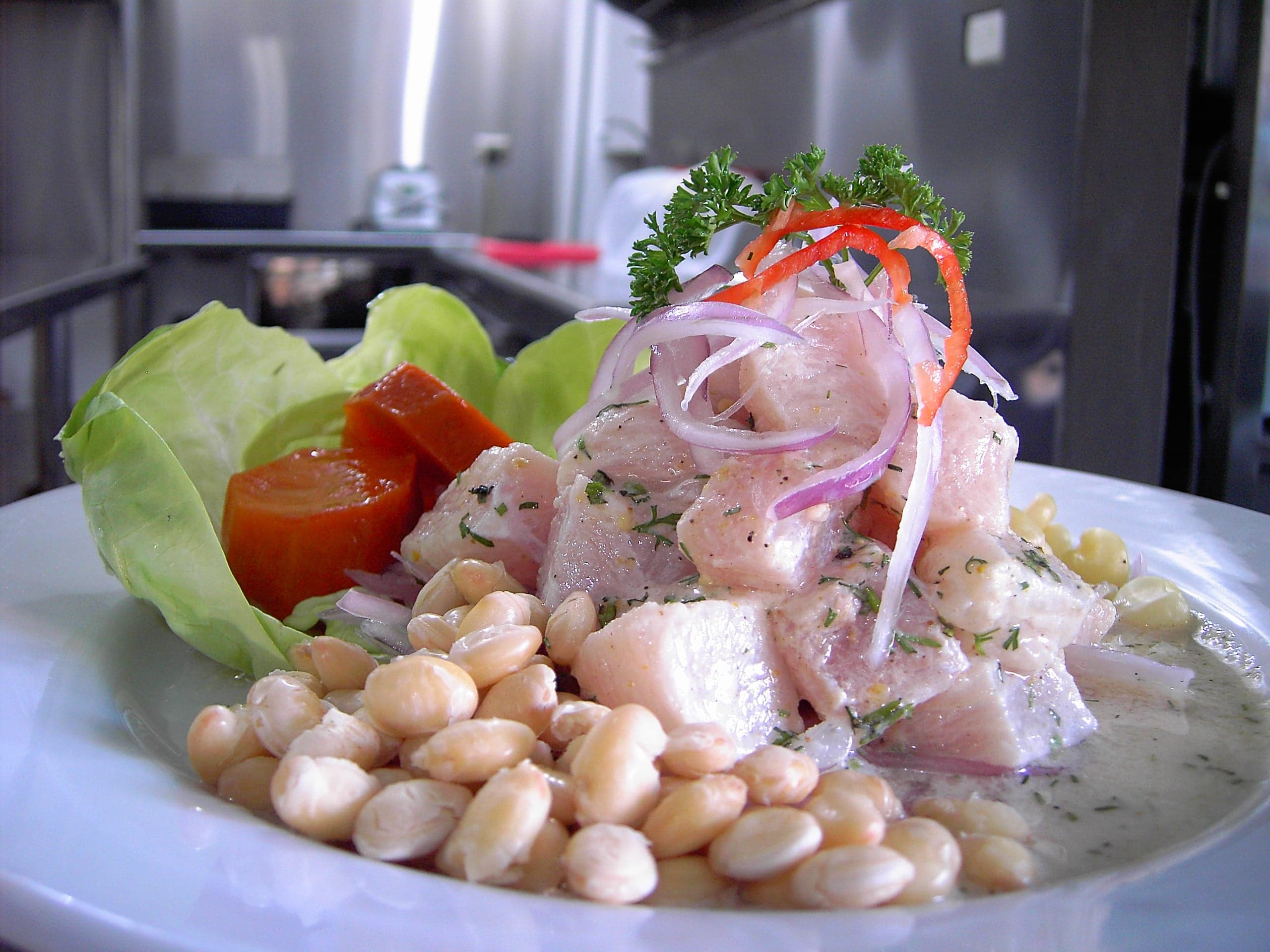 A bowl of bright Ecuadorian ceviche with shrimp, red onion and lime garnish