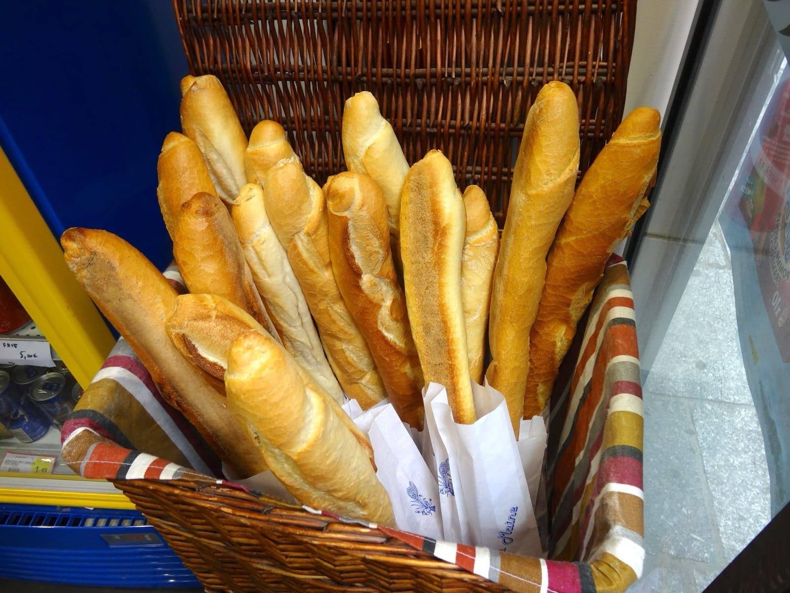 A basket of fresh baguettes in a French bakery