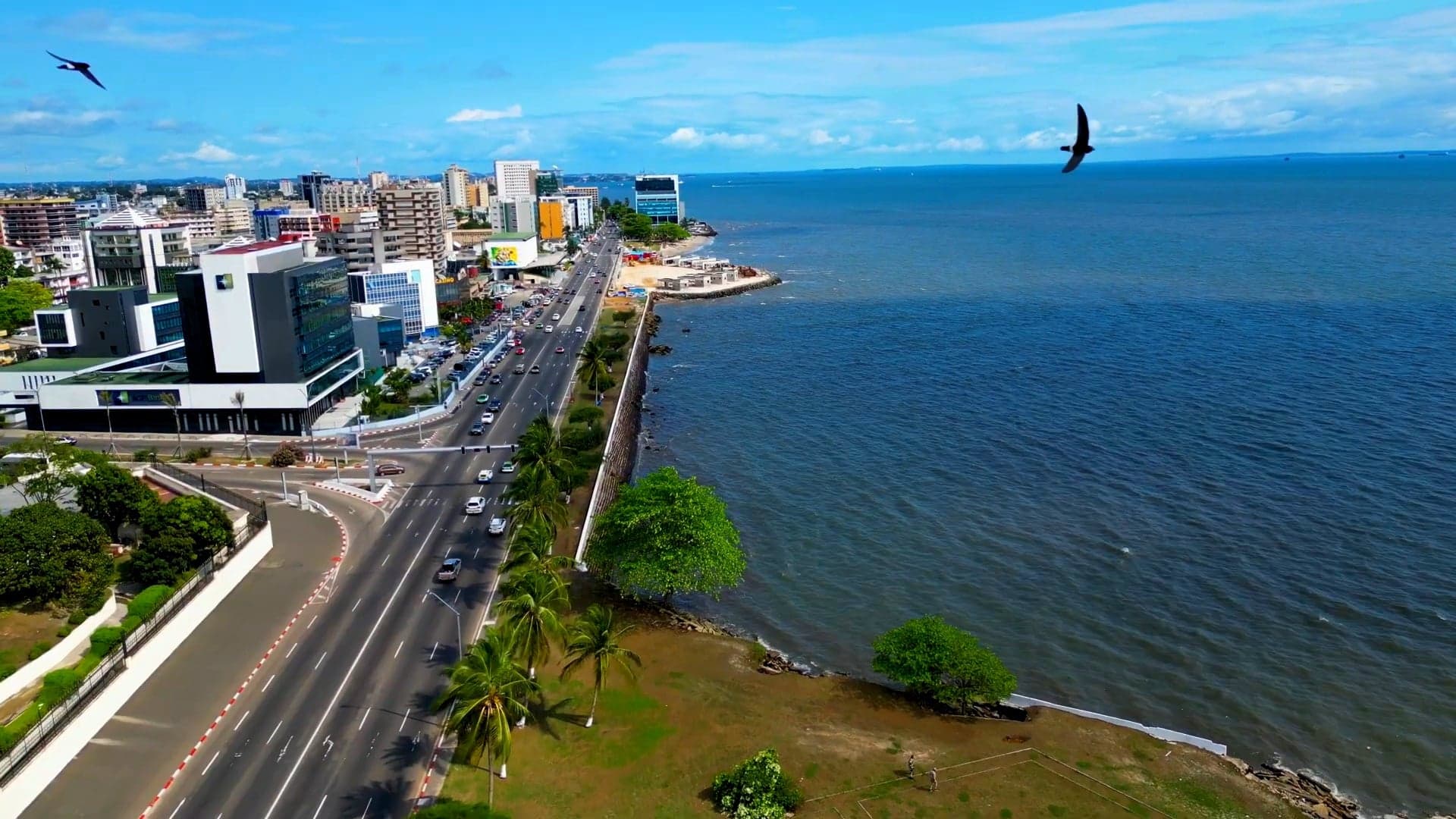 The Libreville seafront with palm trees, colourful buildings and the Atlantic Ocean