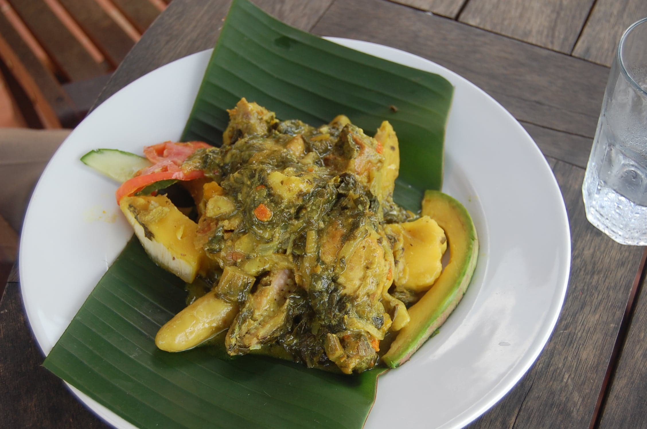 A large pot of Grenadian oil down with breadfruit, callaloo and salt fish visible