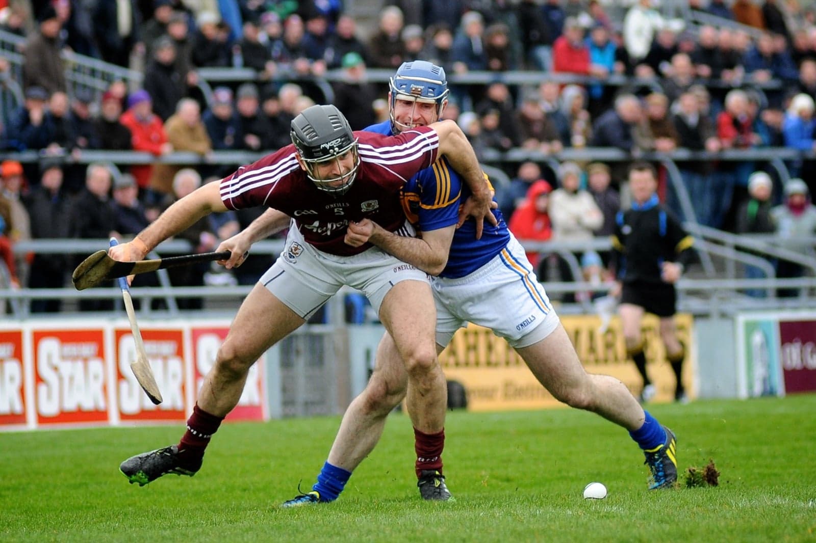 A hurling player striking a sliotar with a wooden hurley