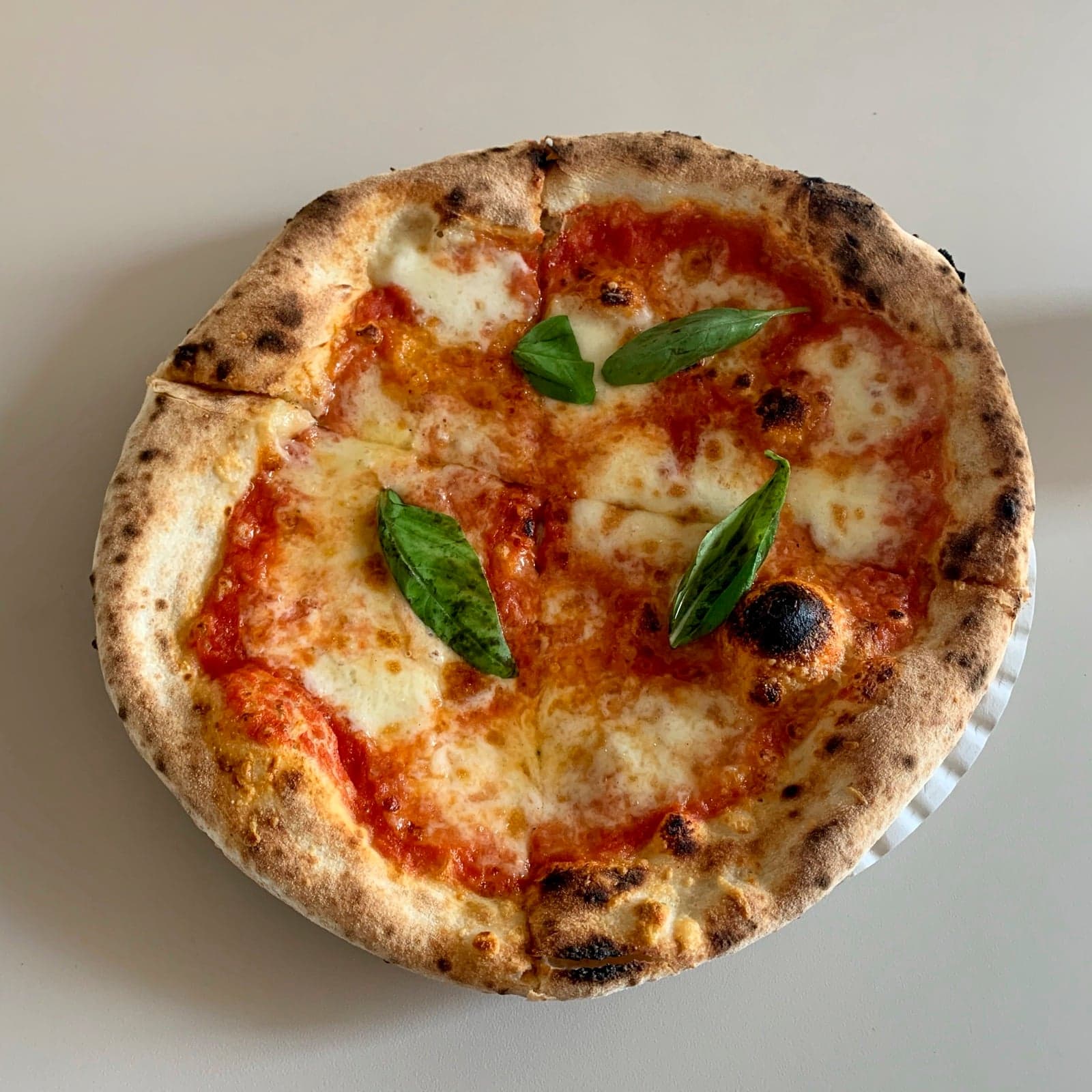 A classic Neapolitan Margherita pizza with tomato, mozzarella and basil
