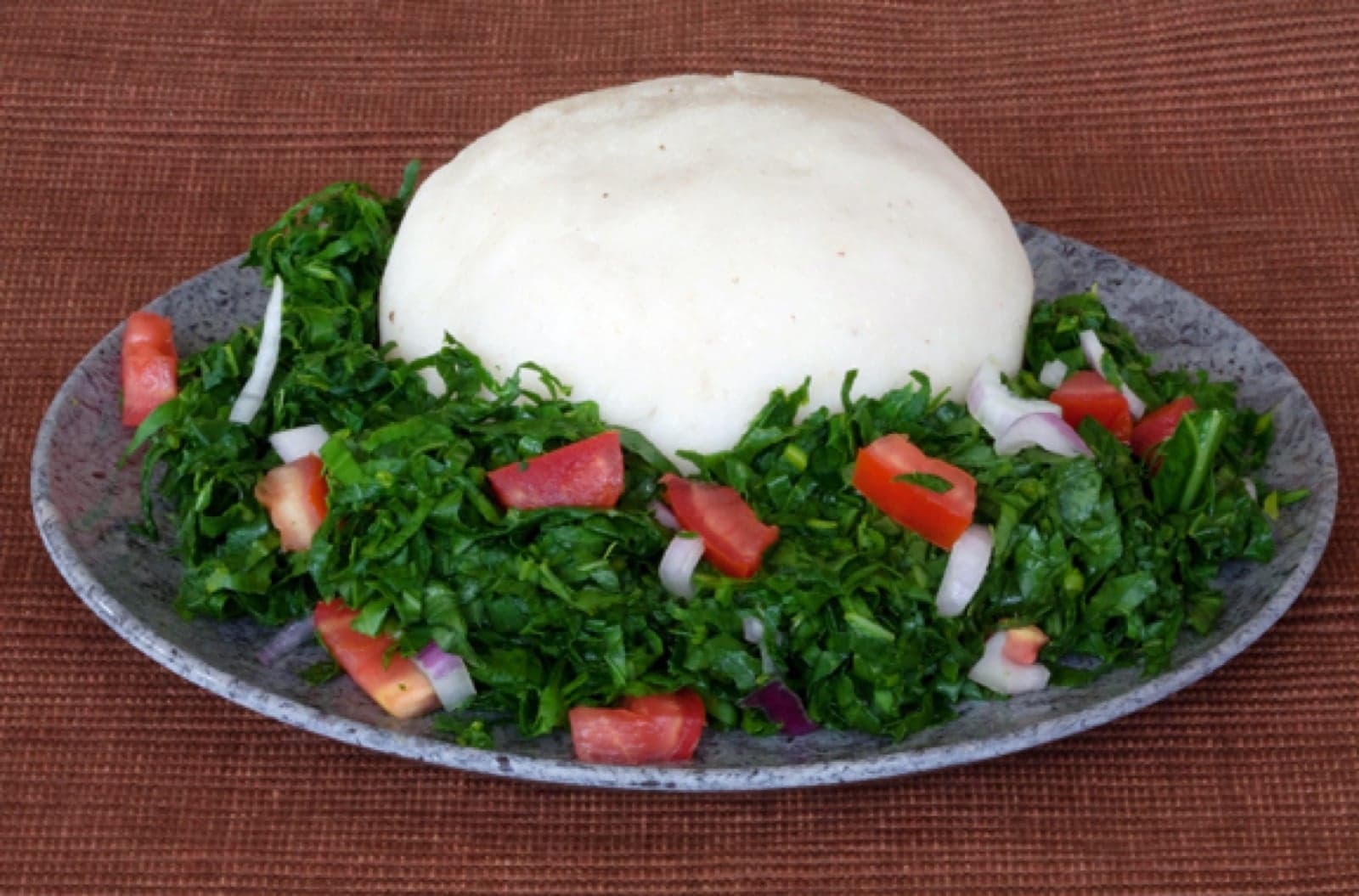 A plate of ugali served with sukuma wiki
