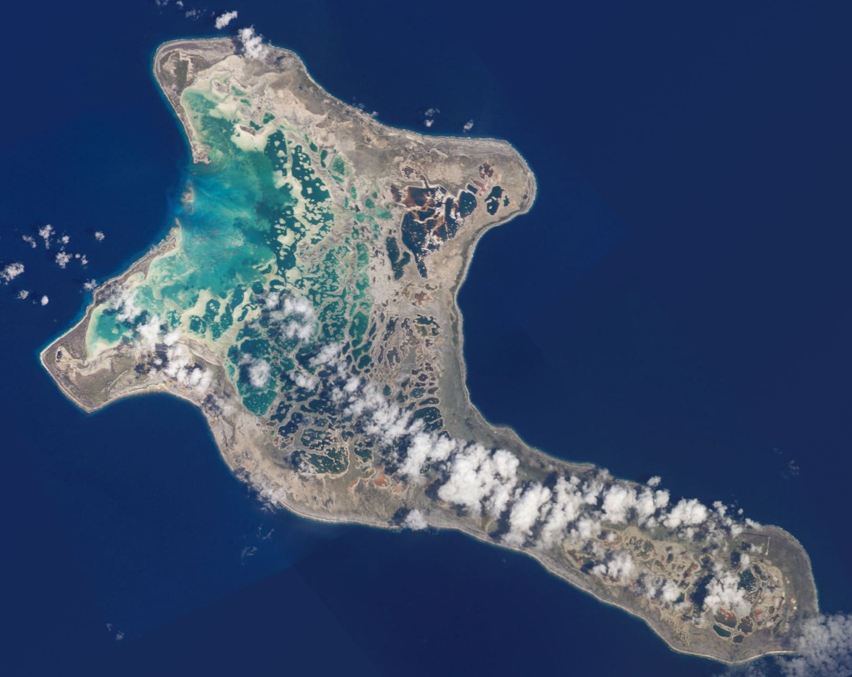 Shallow turquoise lagoon waters of Kiritimati atoll stretching to the horizon
