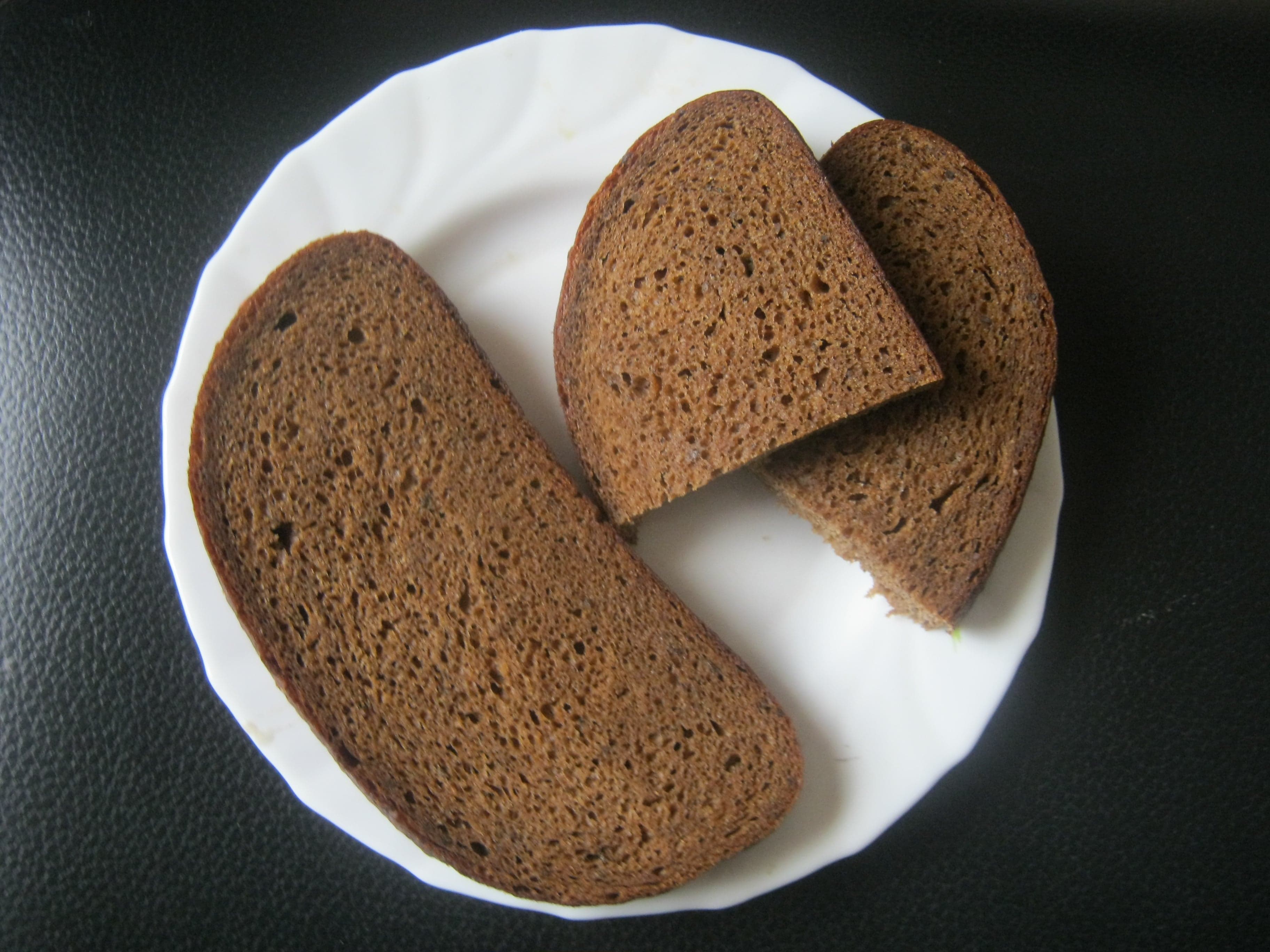 Thick slices of dark Latvian rye bread on a wooden board