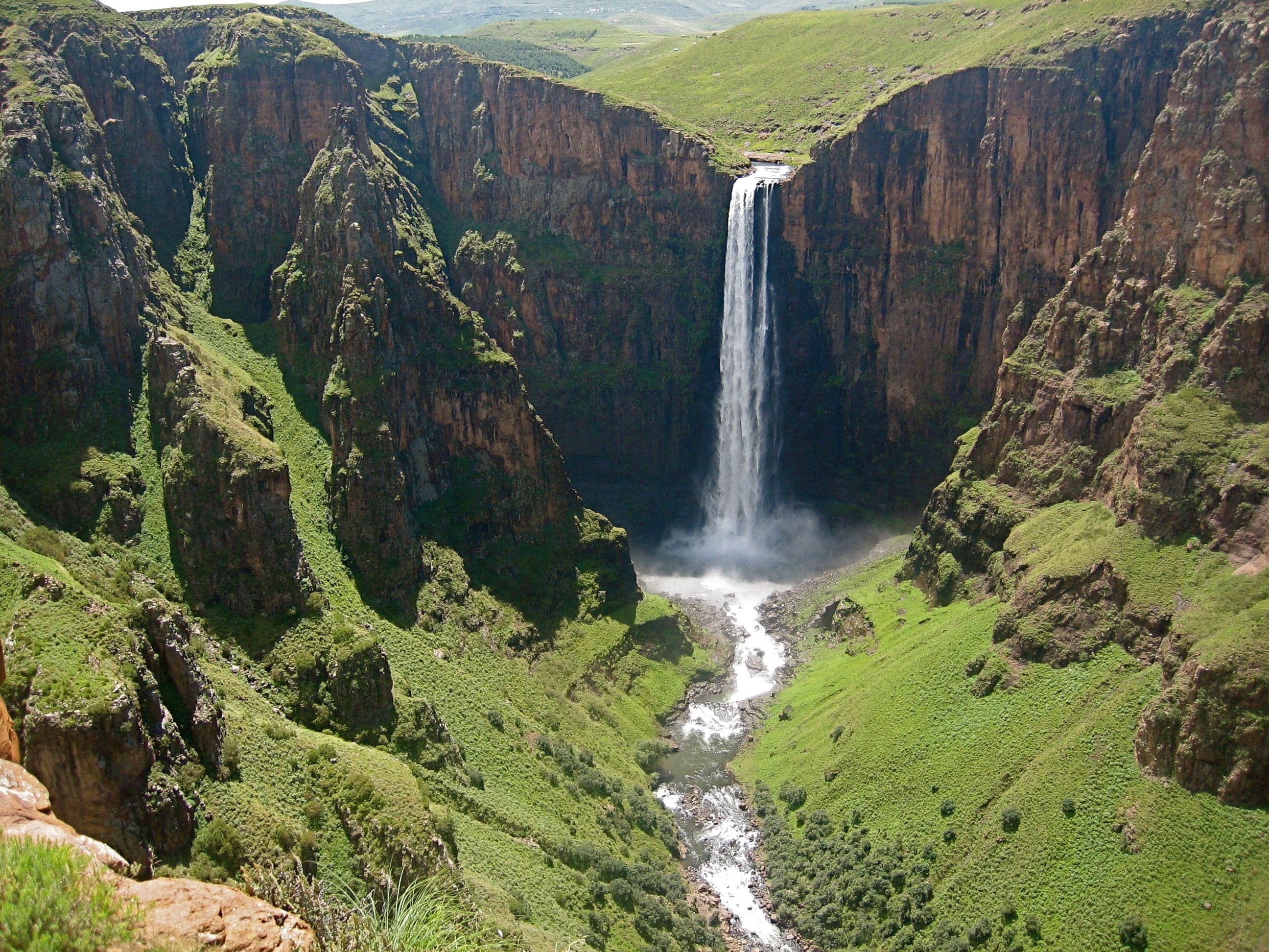 Maletsunyane Falls plunging into a deep gorge surrounded by green highland hills