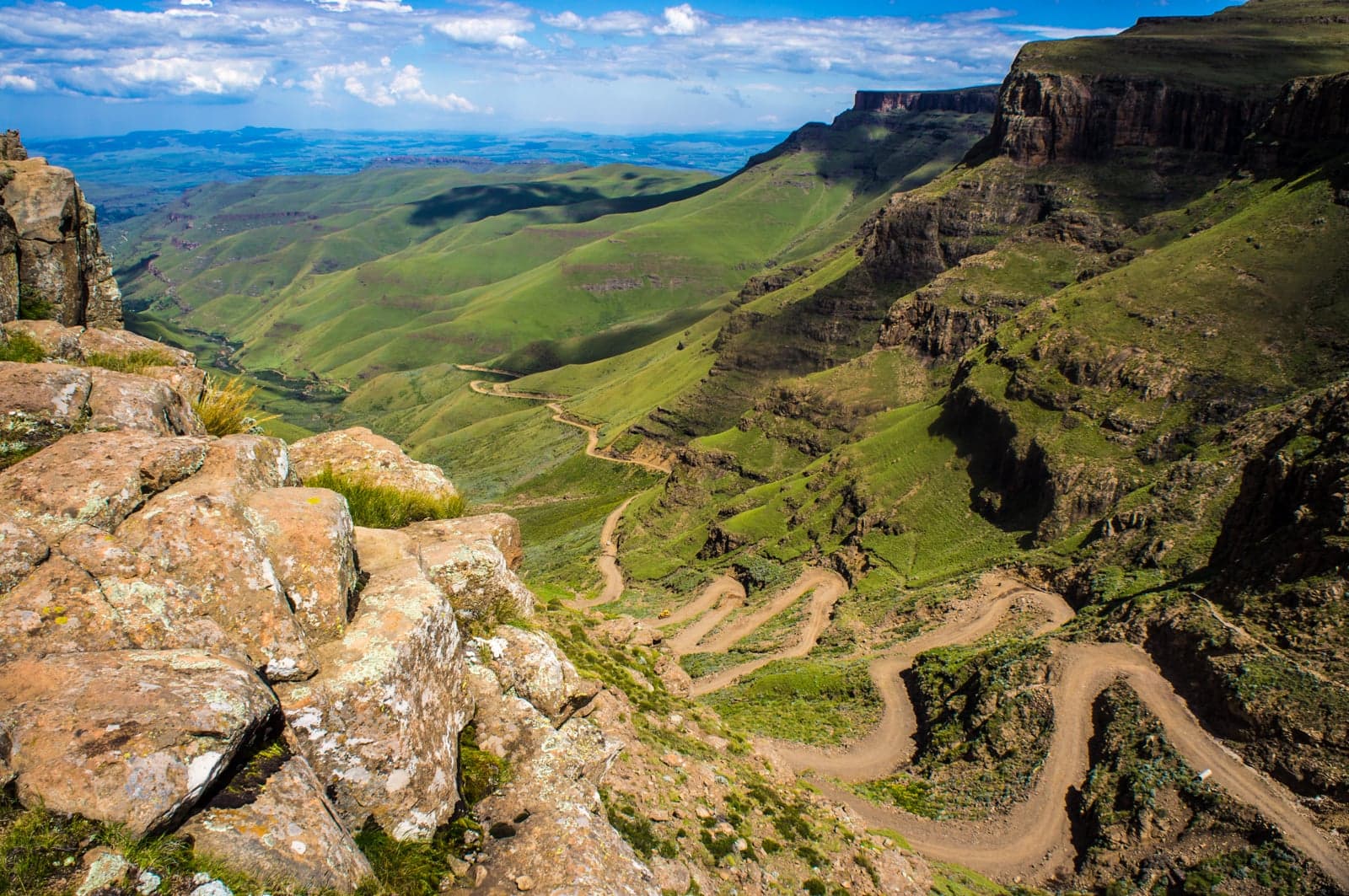 A winding dirt road zigzagging steeply up the Sani Pass mountain face