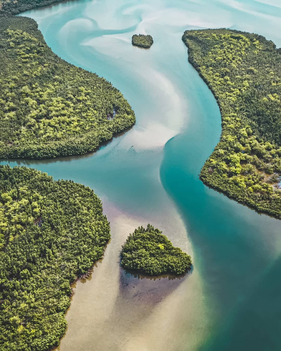 Calm waters of Lake Piso lagoon at sunset with mangrove trees along the shore