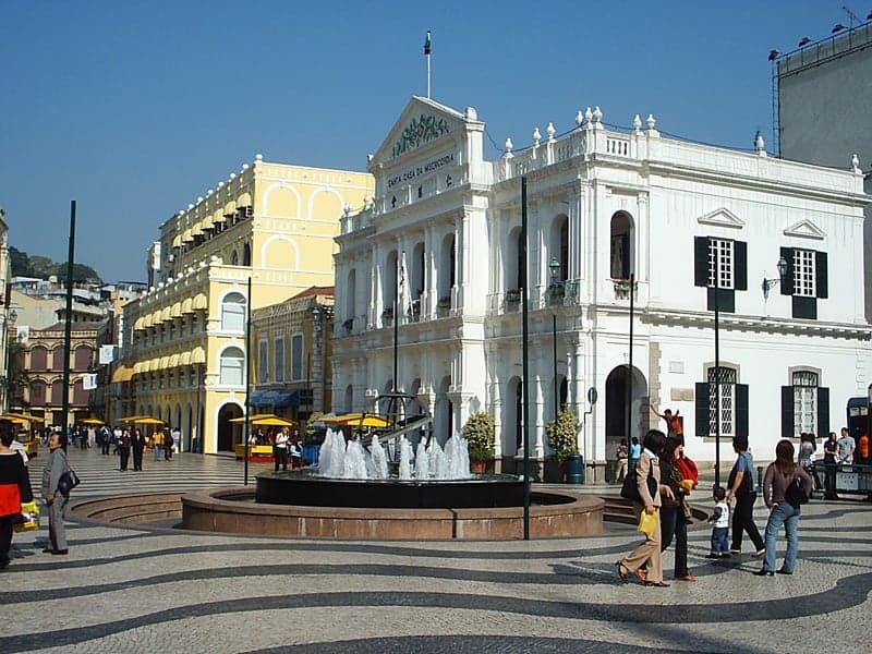 The black-and-white wavy mosaic pavement of Senado Square in Macau with colourful buildings around it