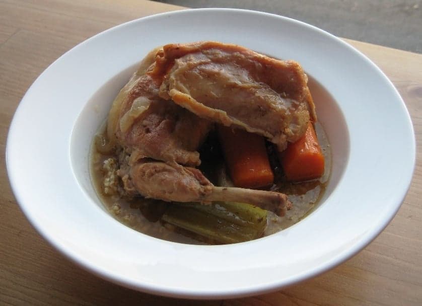 A bubbling pot of Maltese rabbit stew with herbs and tomato sauce