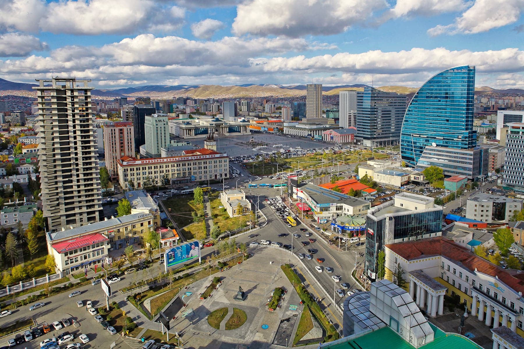 Ulaanbaatar's skyline with modern buildings and a ger district in the foreground