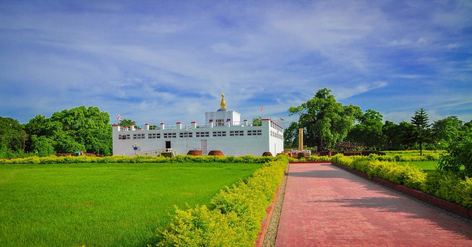 A peaceful pond and ancient ruins under trees at Lumbini