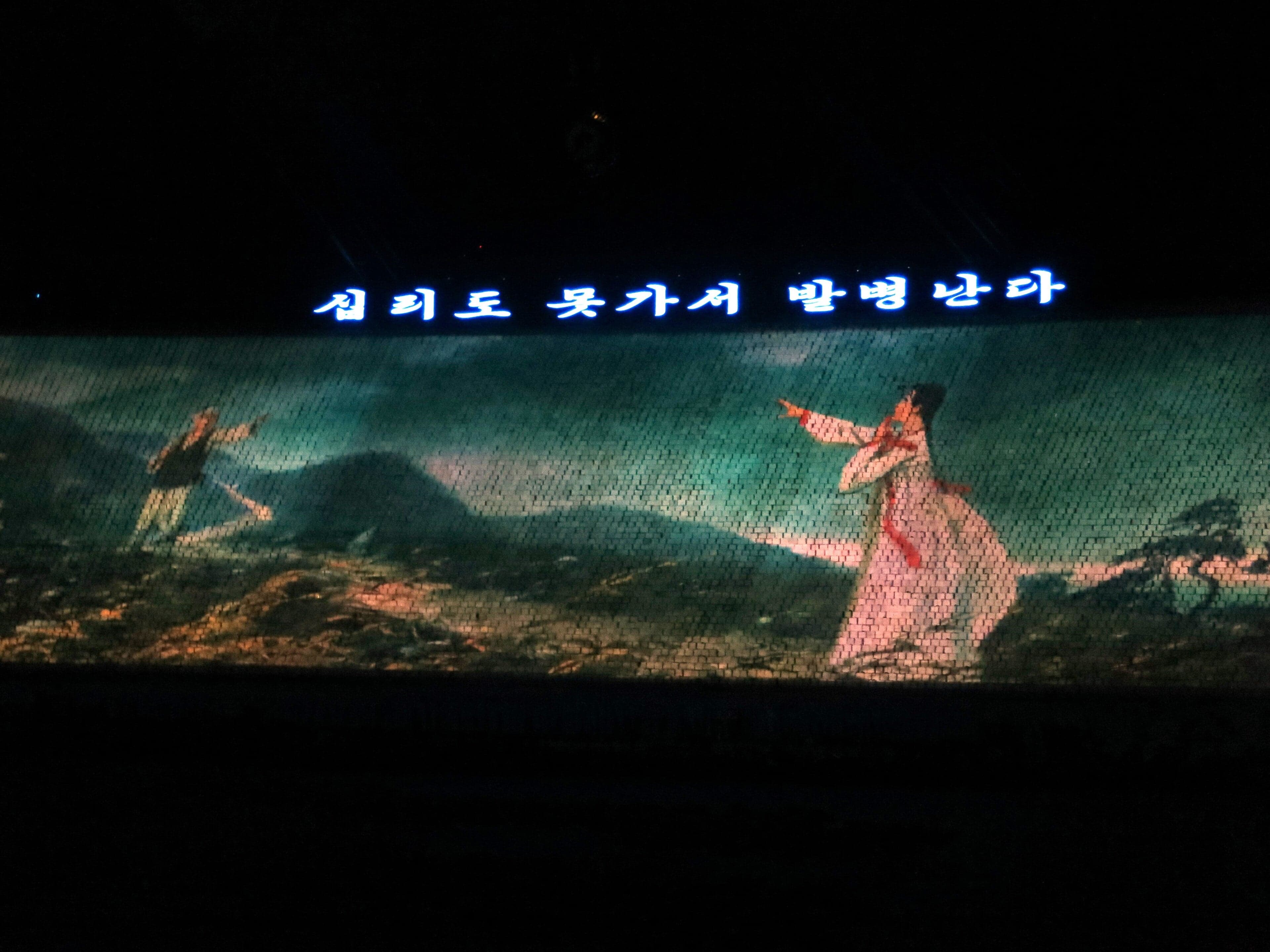 A group of Korean performers in colourful traditional dress singing and playing instruments
