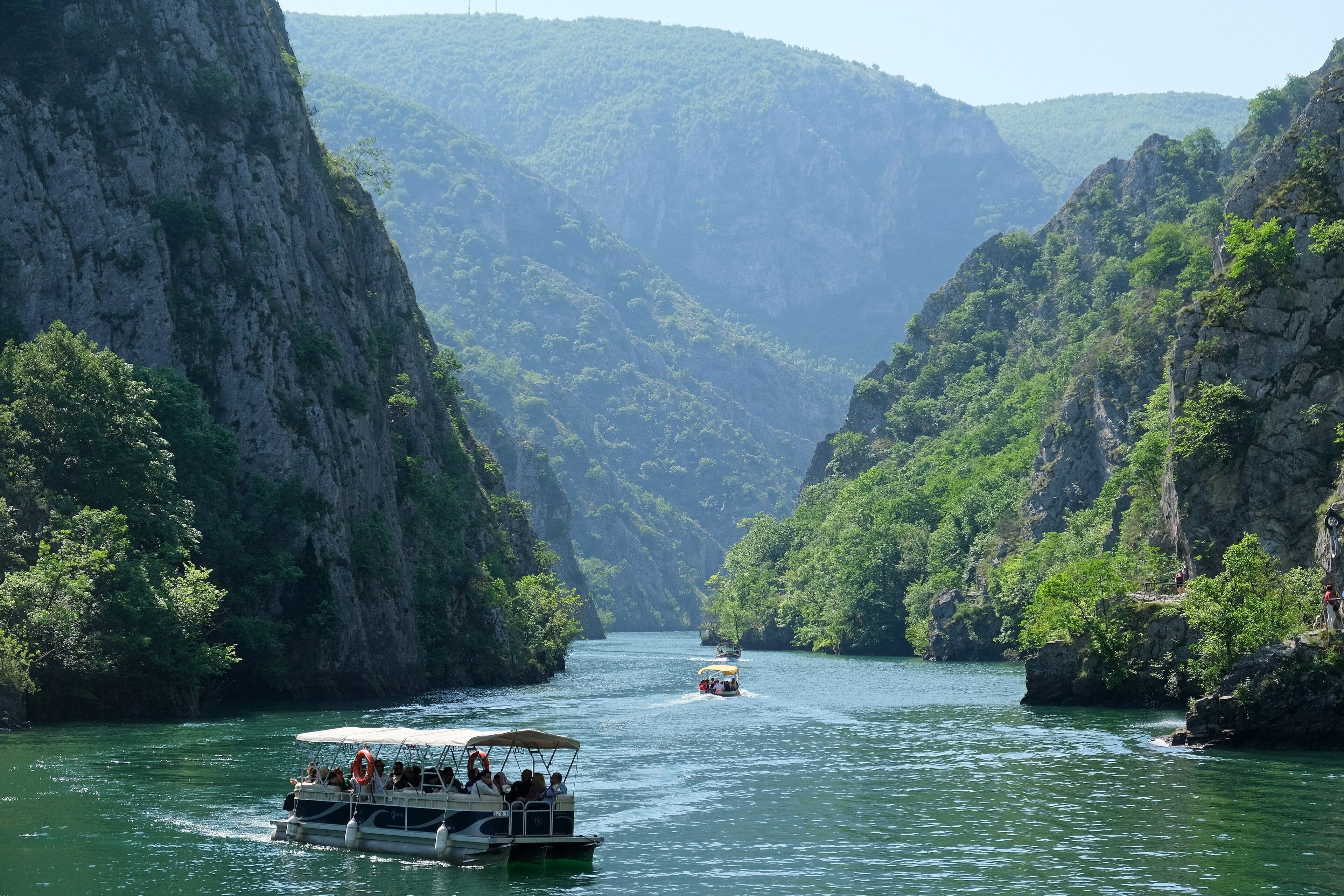 Emerald green water flowing through the steep rocky walls of Matka Canyon