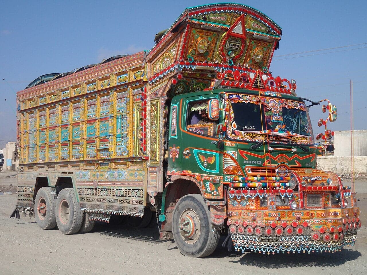 A Pakistani lorry covered head to toe in colourful painted patterns, flowers, mirrors and metal trim