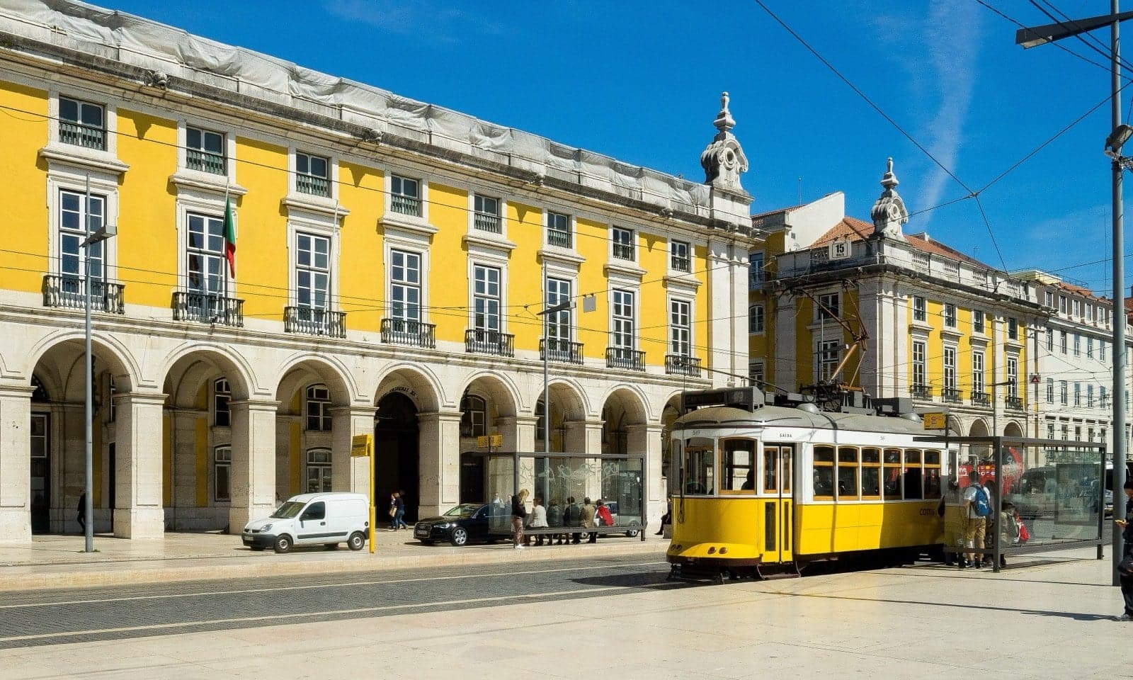 A historic yellow Tram 28 climbing a steep narrow street in Lisbon