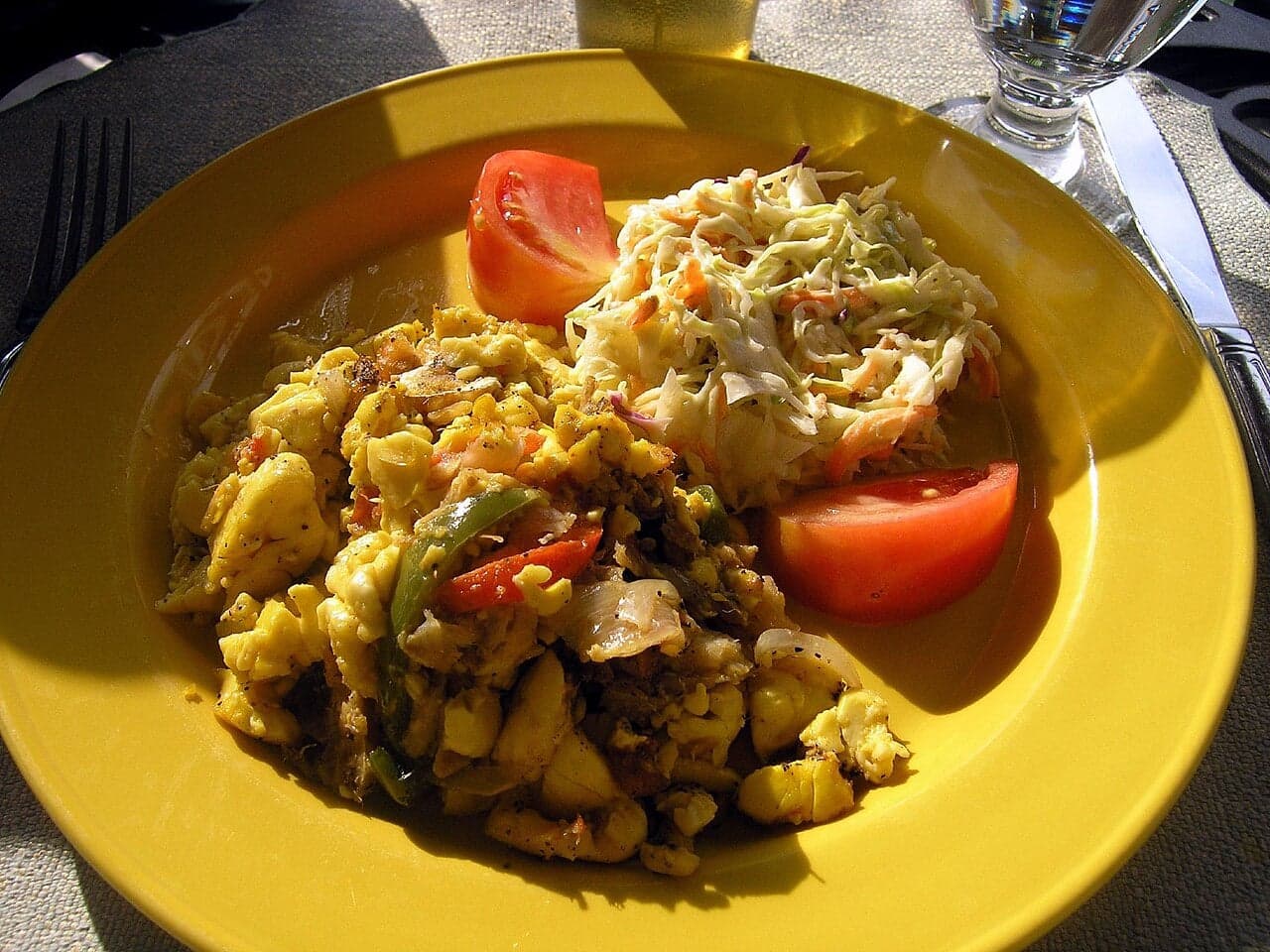 A plate of boiled green bananas and seasoned saltfish with onions and peppers