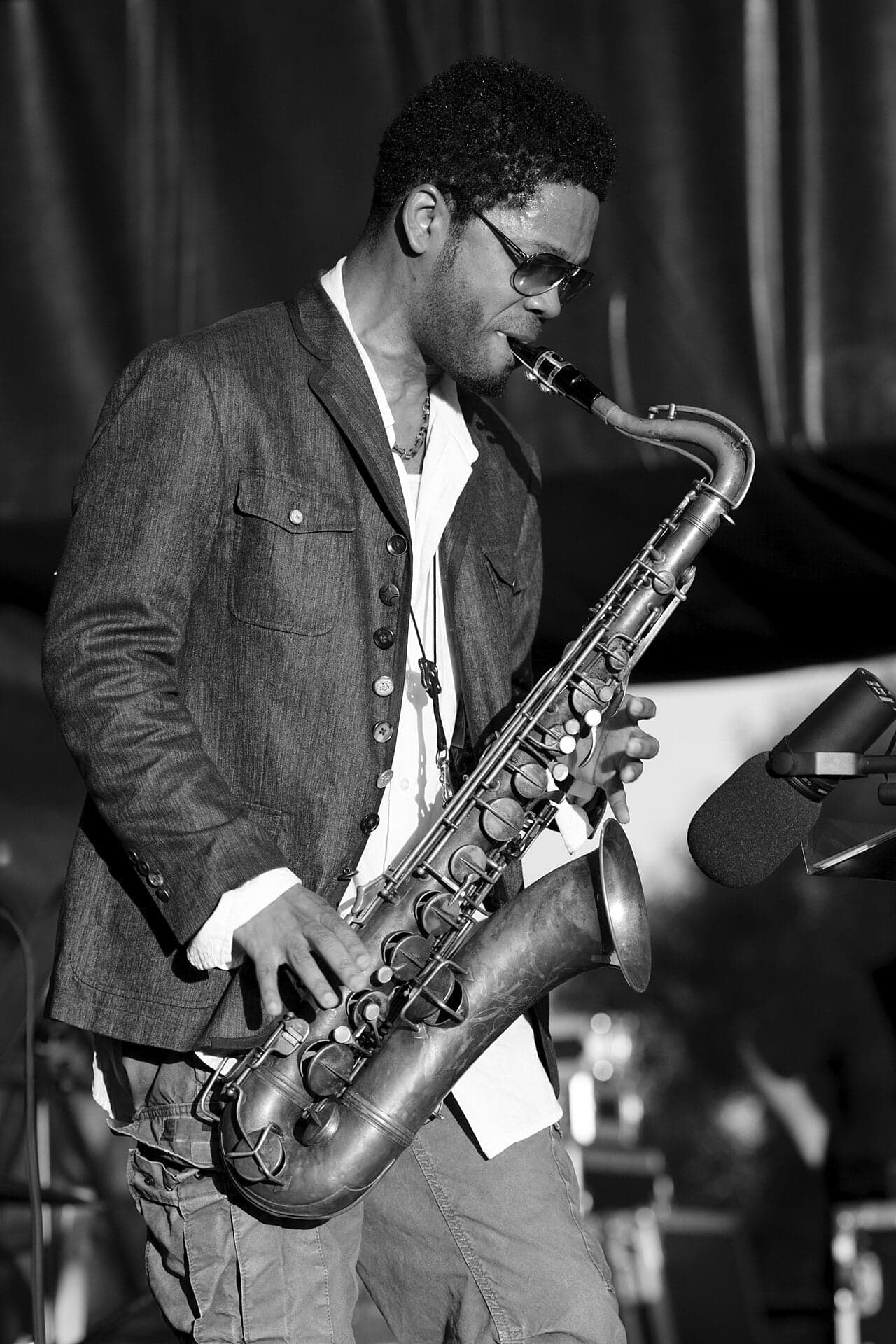 A jazz musician performing on an outdoor stage at the Saint Lucia Jazz Festival with the sea behind