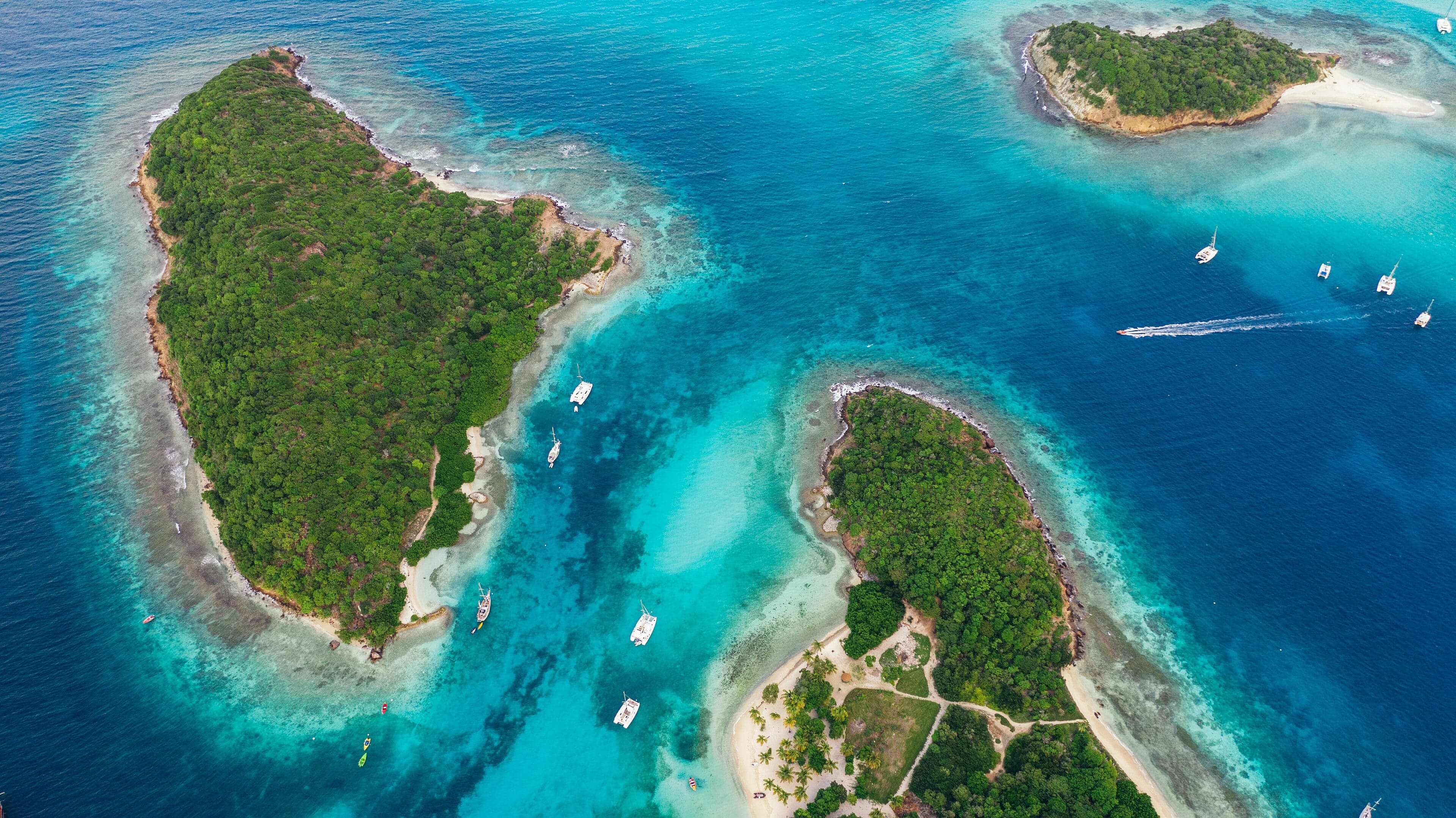 Turquoise lagoon waters around the Tobago Cays with coral reef visible below