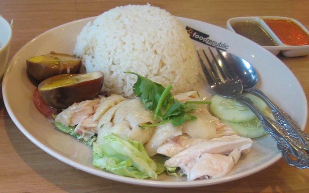 A plate of Hainanese chicken rice with sauces