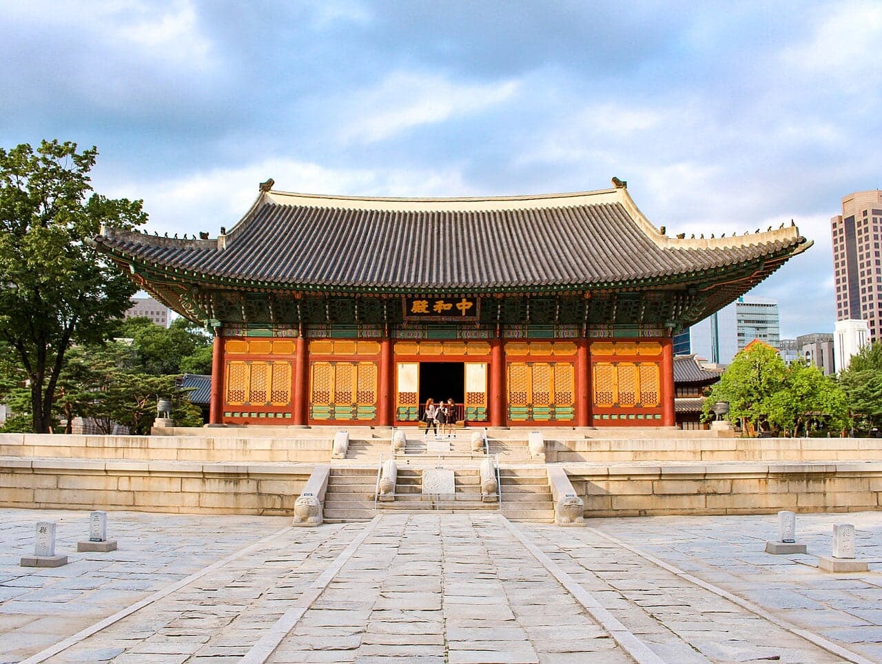 A traditional Korean palace hall with bright red columns and a curved tiled roof