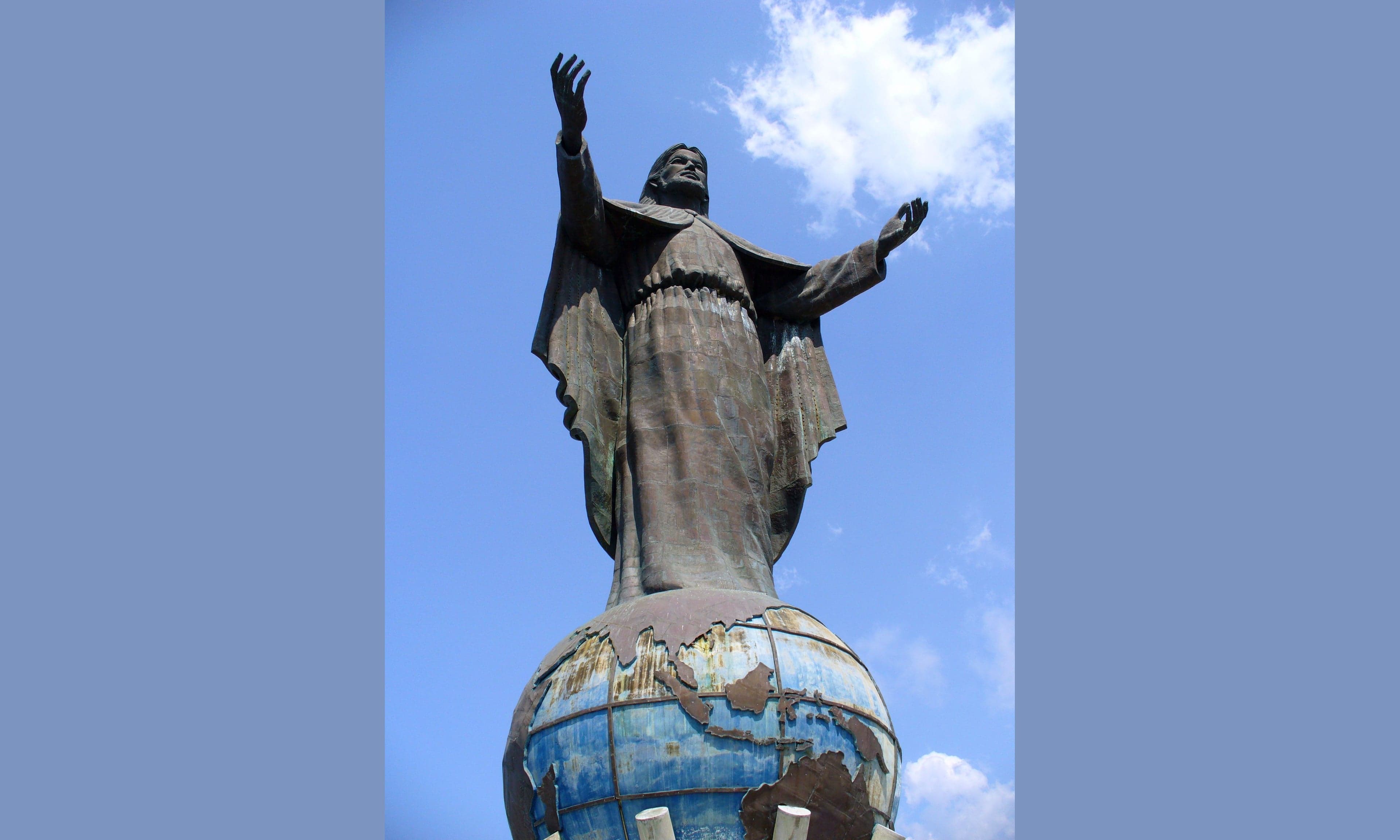 The Cristo Rei statue on a hilltop with turquoise ocean in the background