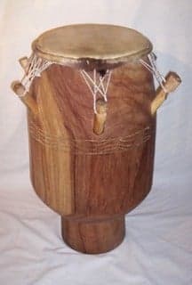 Ewe drummers in traditional white cloth playing at an outdoor ceremony