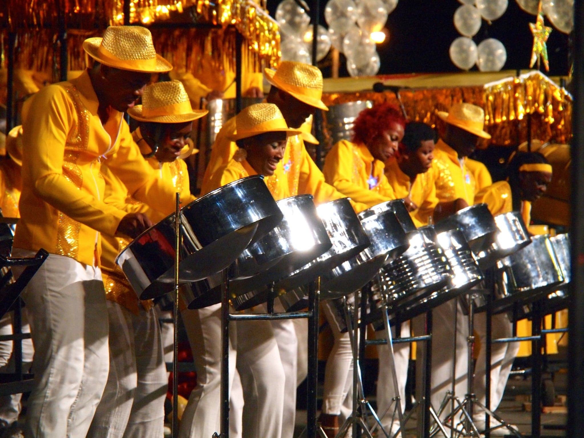 A musician playing a gleaming steelpan drum in Trinidad