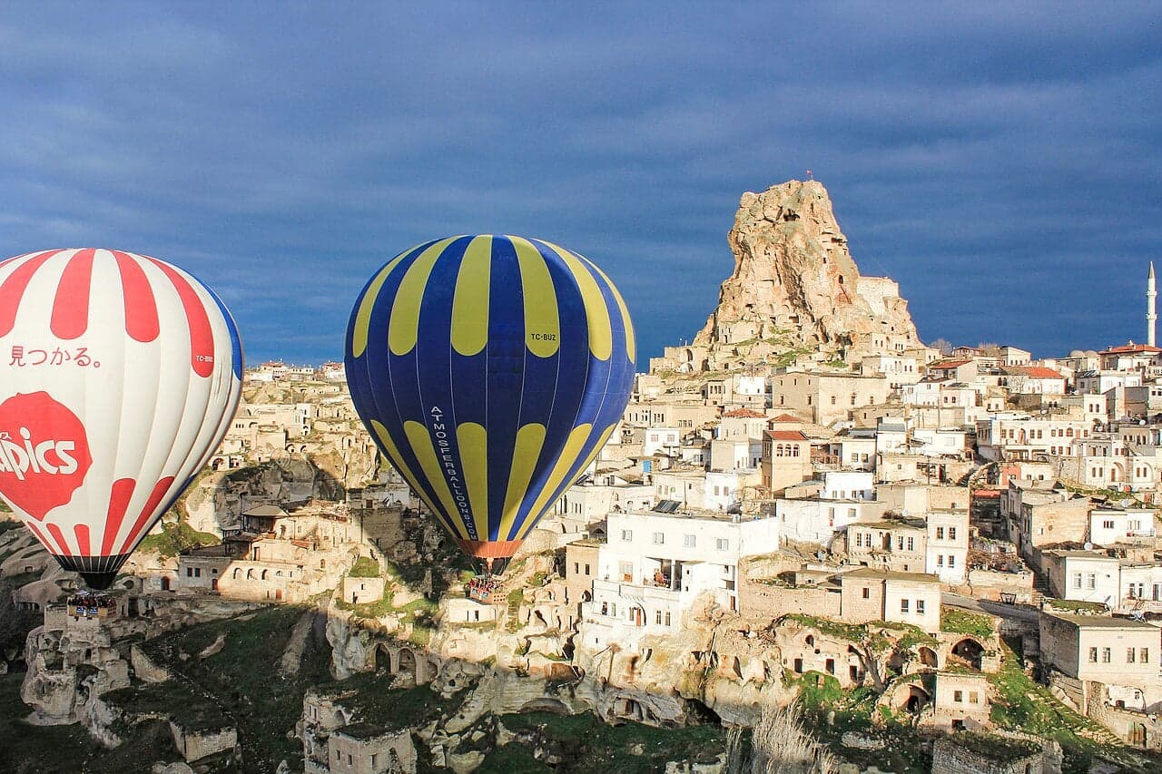 Hot-air balloons rising at sunrise over the fairy chimneys of Cappadocia