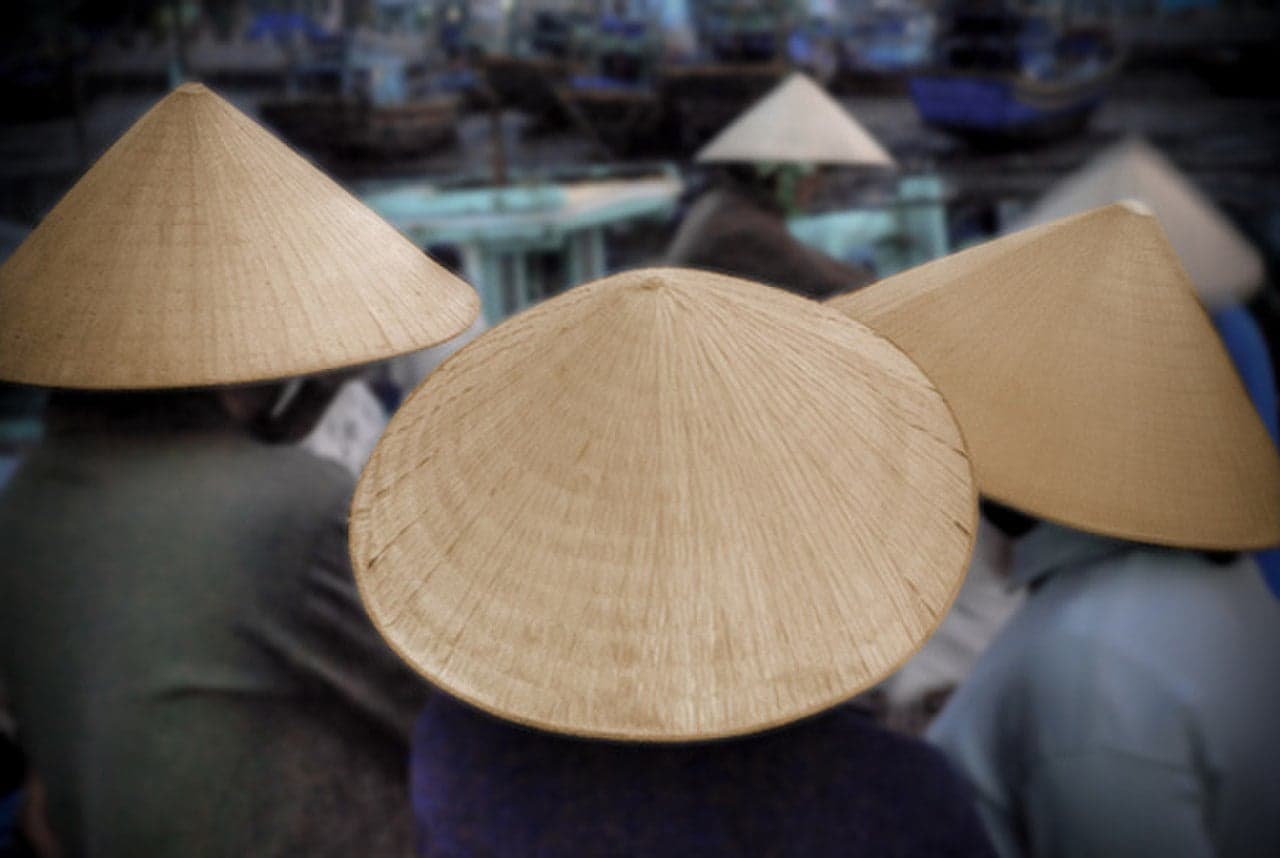 Three traditional Vietnamese conical hats made of woven palm leaves seen from behind