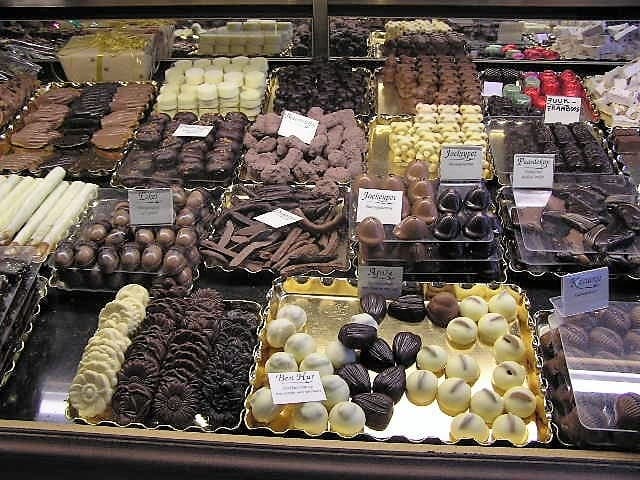 A tray of Belgian pralines with various fillings displayed in a shop window