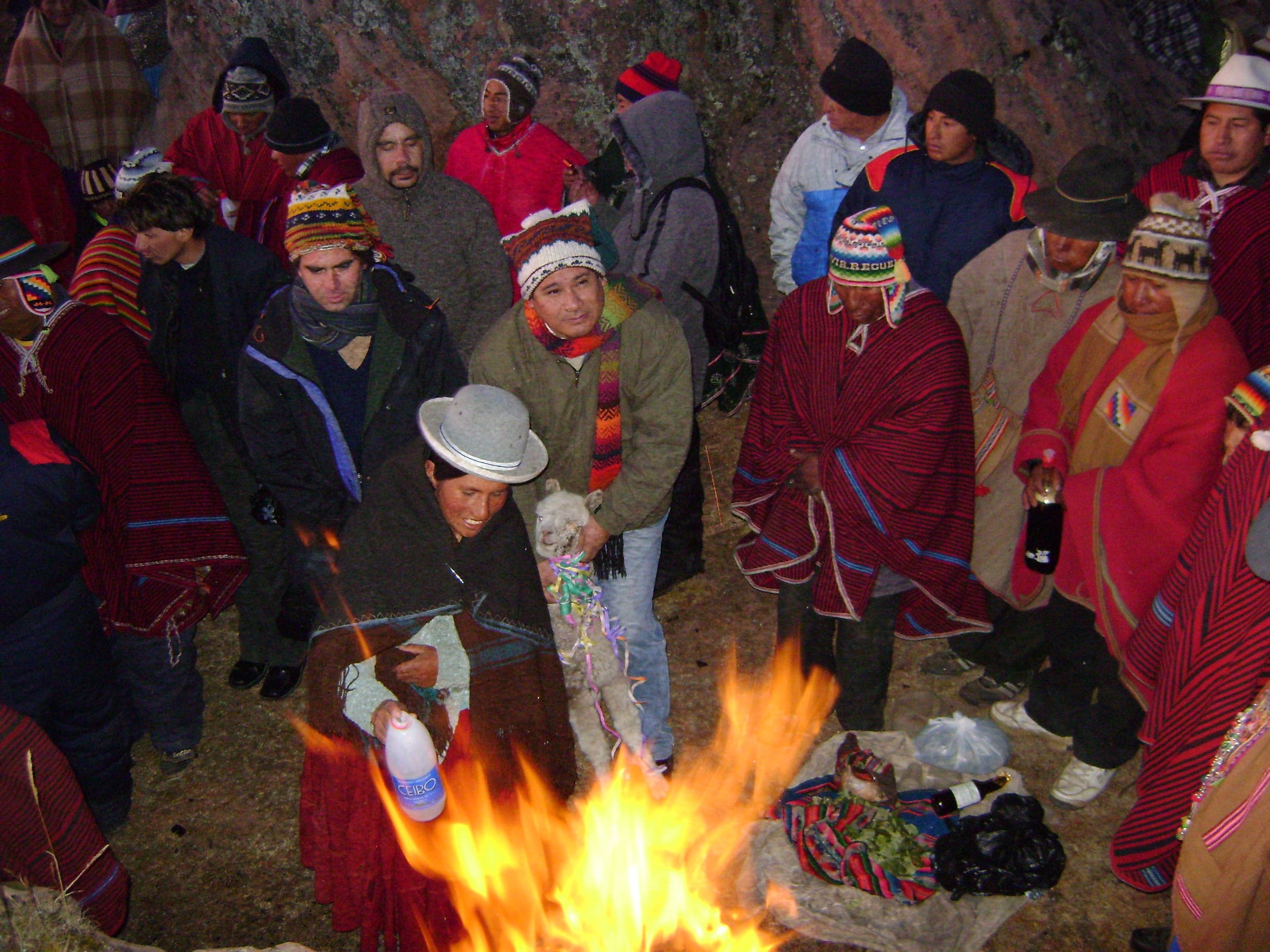 A crowd of people in colourful traditional clothing watching sunrise at Tiwanaku ruins