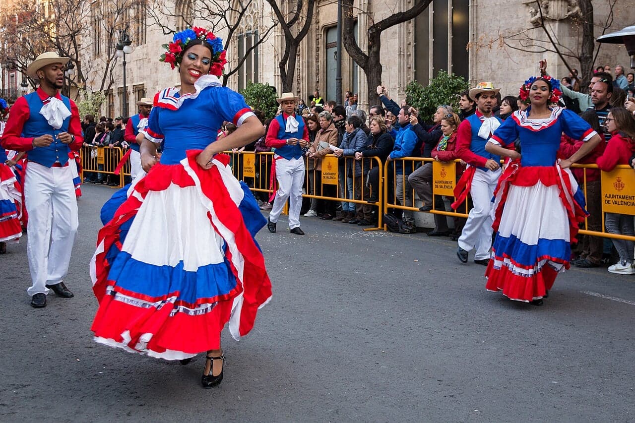 A couple dancing merengue in colourful costumes at a festival in the Dominican Republic