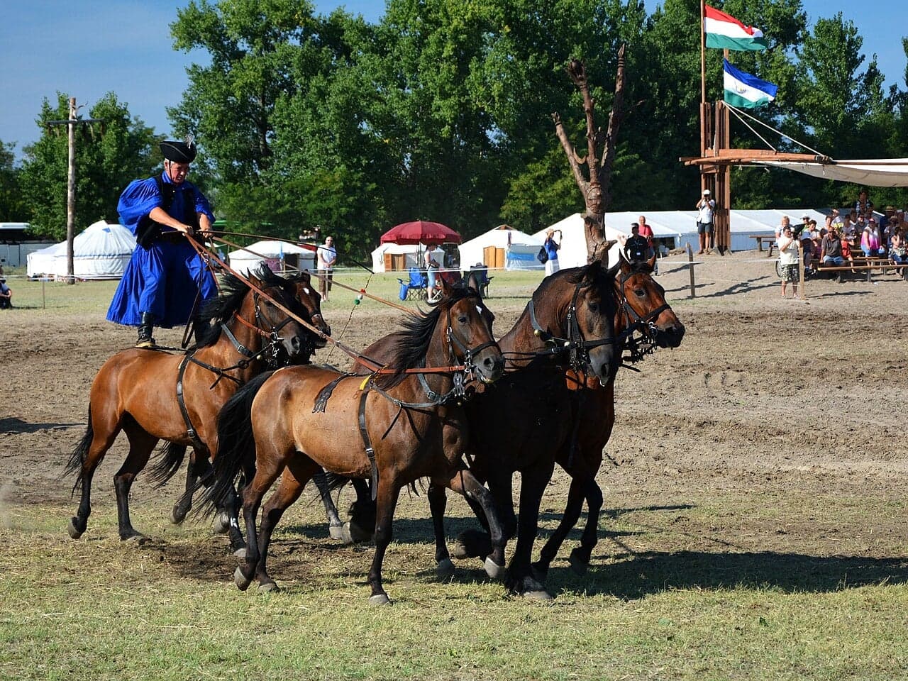 A csikós horseman in traditional embroidered costume riding across the Puszta