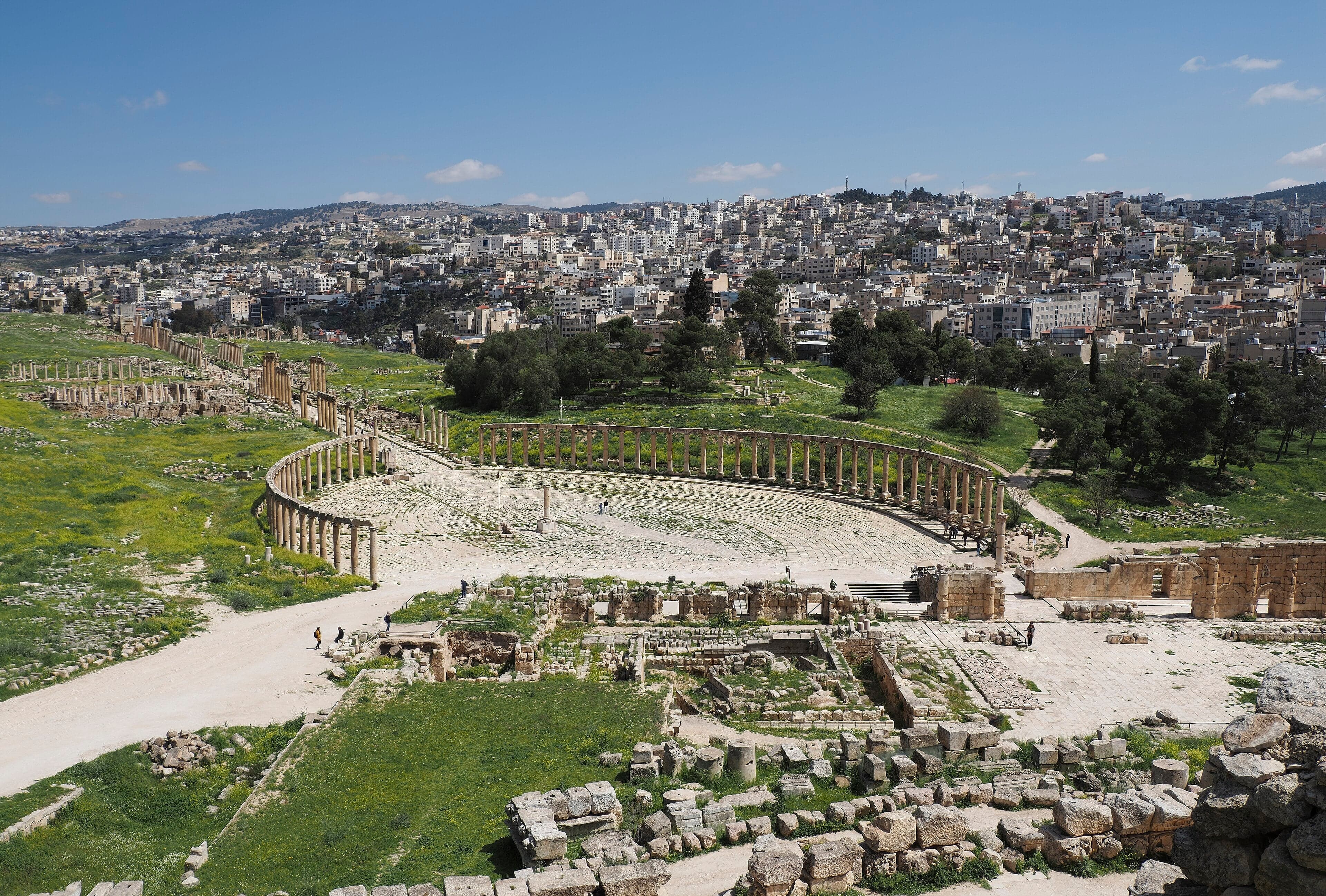 Rows of tall Roman columns lining the oval plaza of ancient Jerash in Jordan