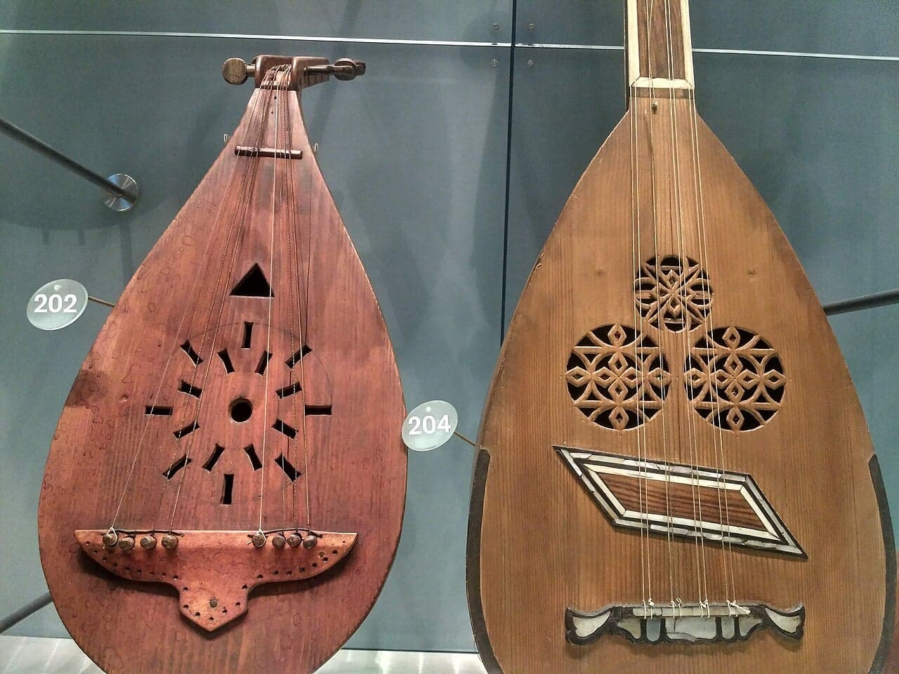 A musician playing an oud, a large teardrop-shaped stringed instrument with an intricately carved sound hole