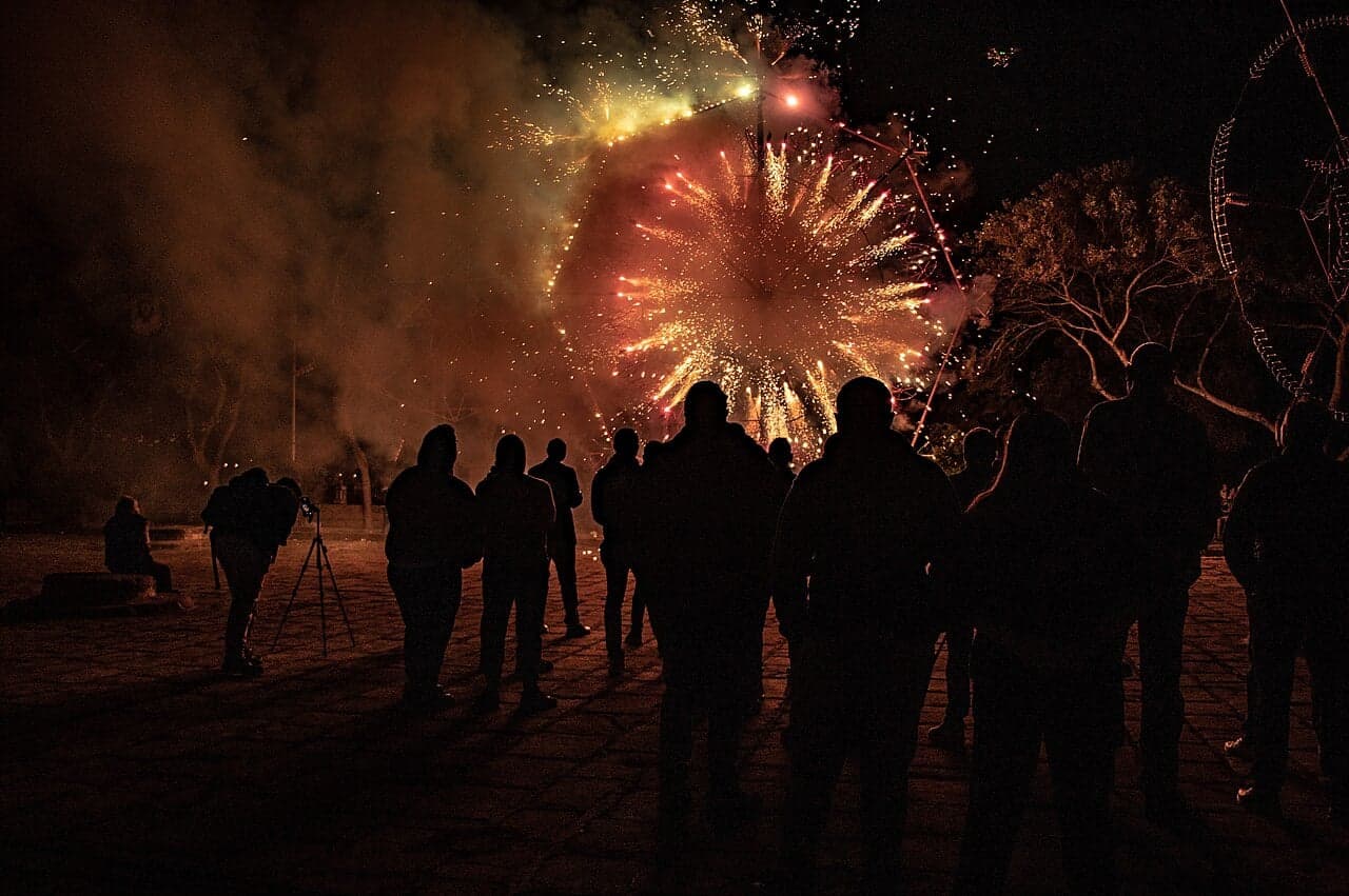 Decorated lights and crowds in a Maltese village square during a festa