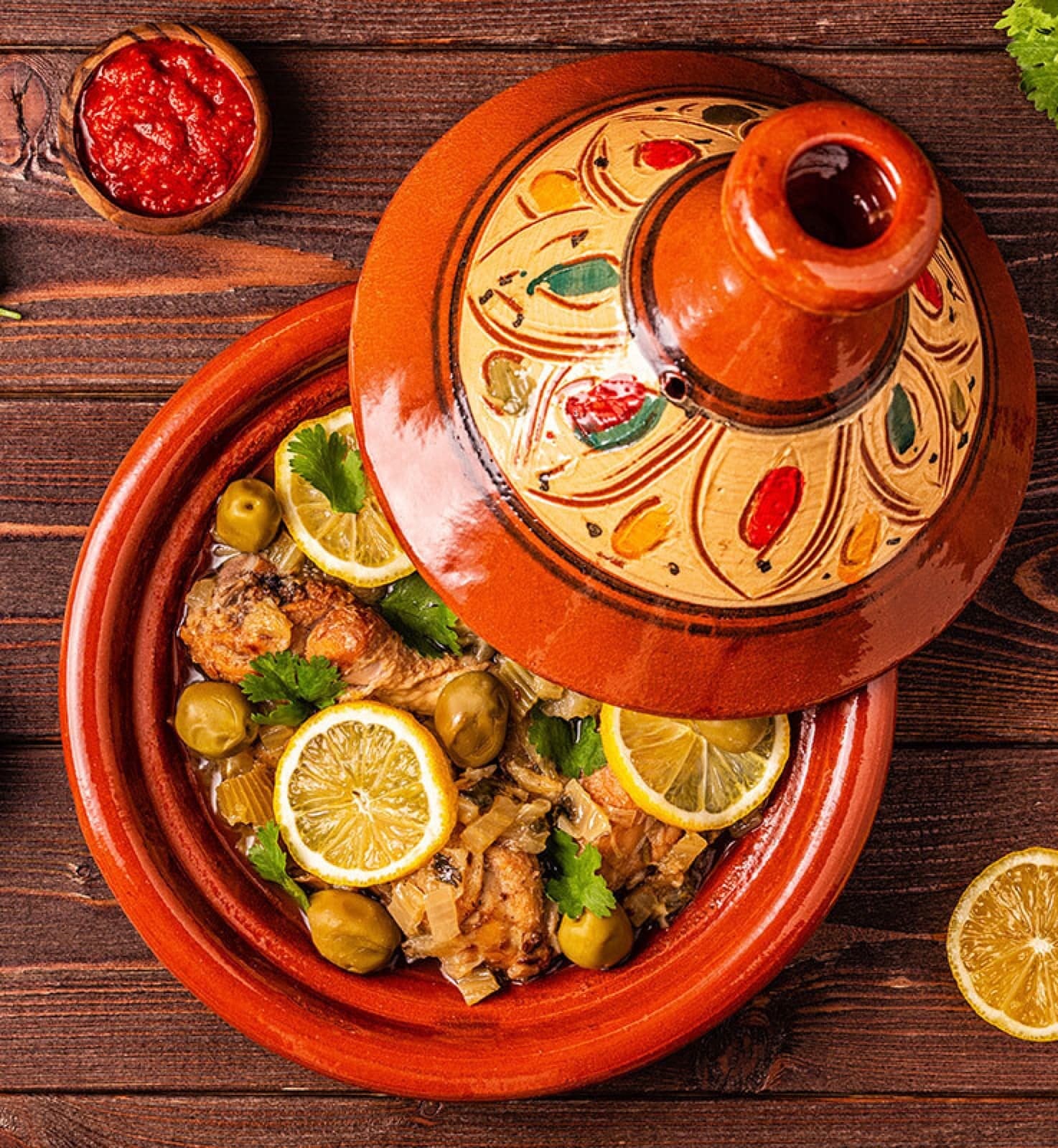 A traditional Moroccan tagine pot with cone-shaped lid steaming on a table