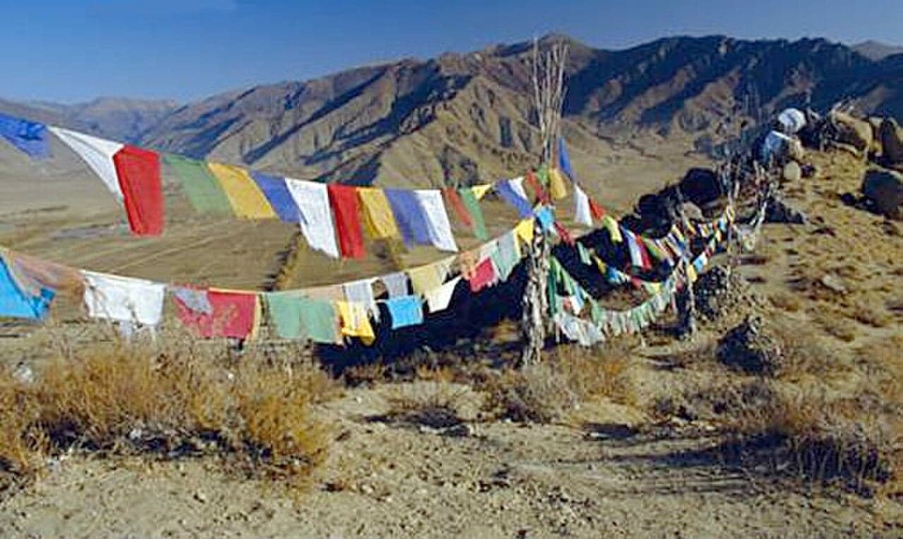Strings of colourful prayer flags fluttering against snow-capped mountains