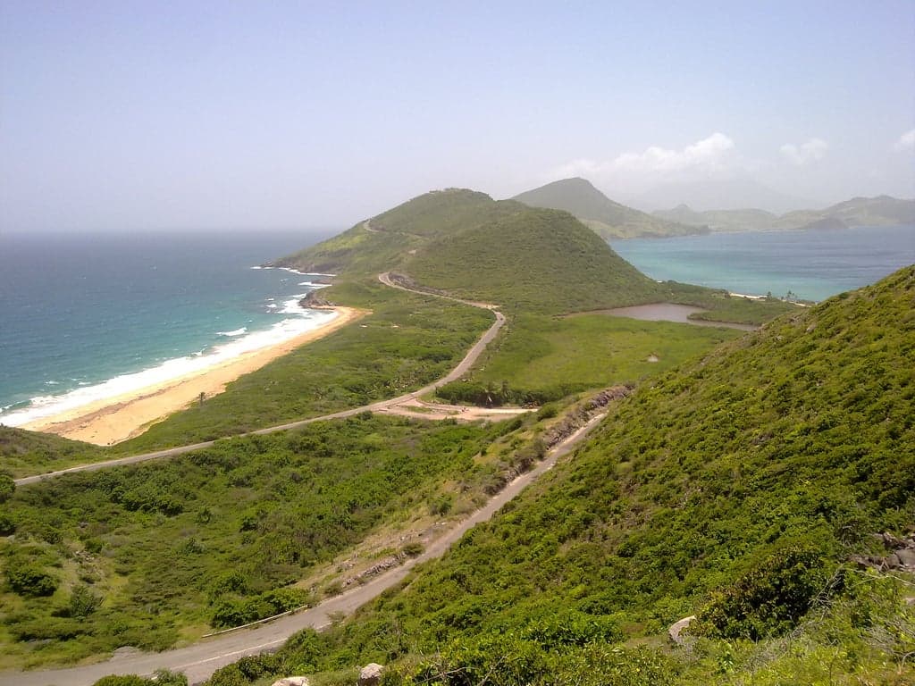 A view across The Narrows channel between Saint Kitts and Nevis with blue water and green hills
